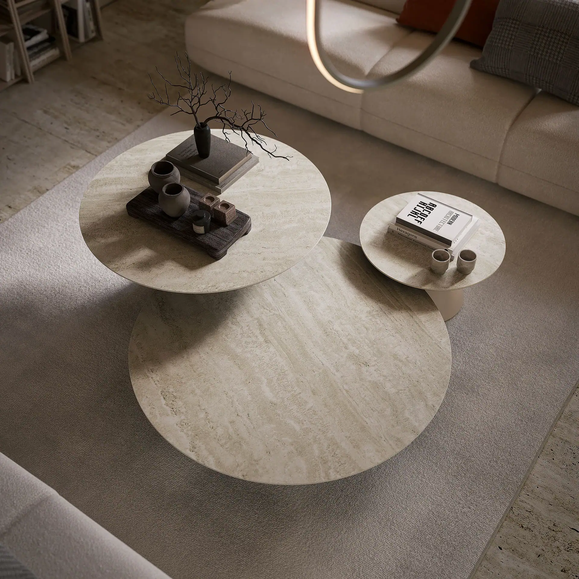 Contemporary beige marble coffee tables with decorative vases and books in a cozy living room.