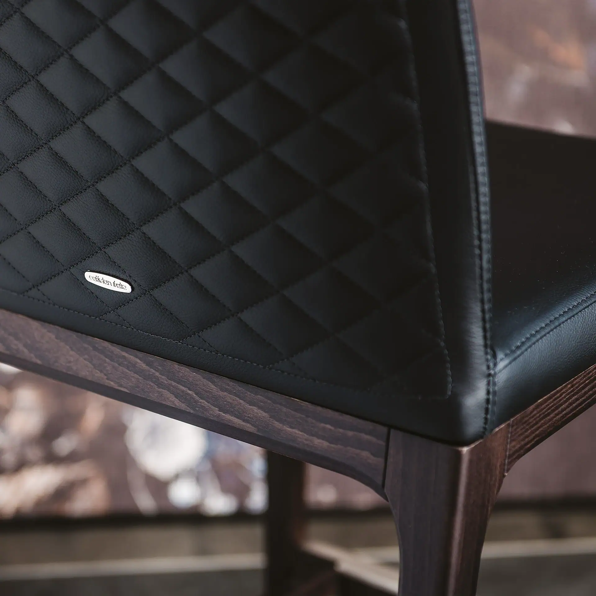 Close-up of black quilted upholstery on the Arcadia stool by Sklar Furnishings.
