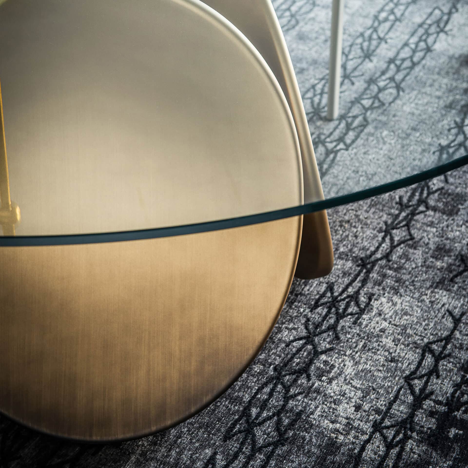 Elegant Maxim round dining table with glass top and gold finish.