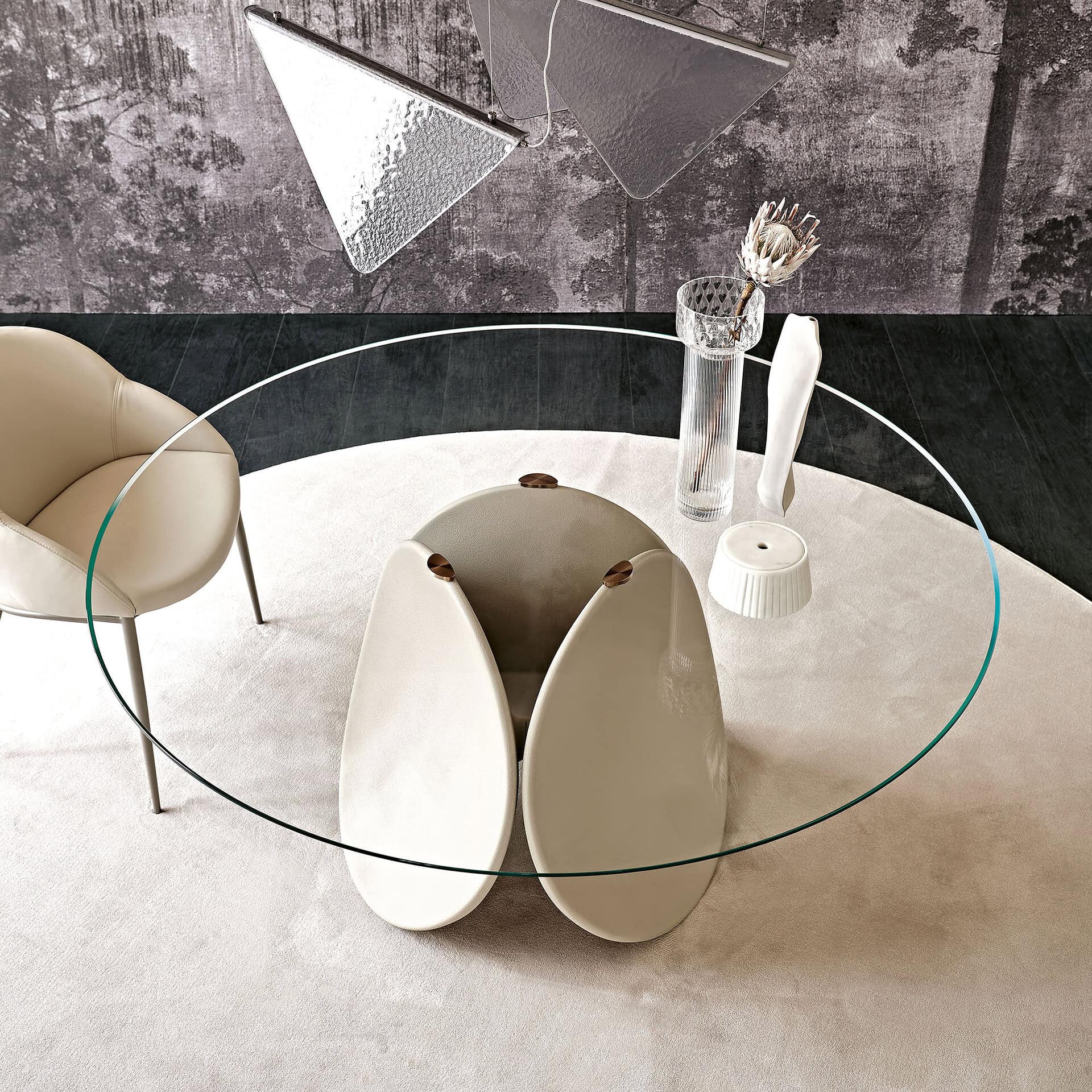 Contemporary Maxim round dining table featuring a glass top and artistic base design. Perfect for st.