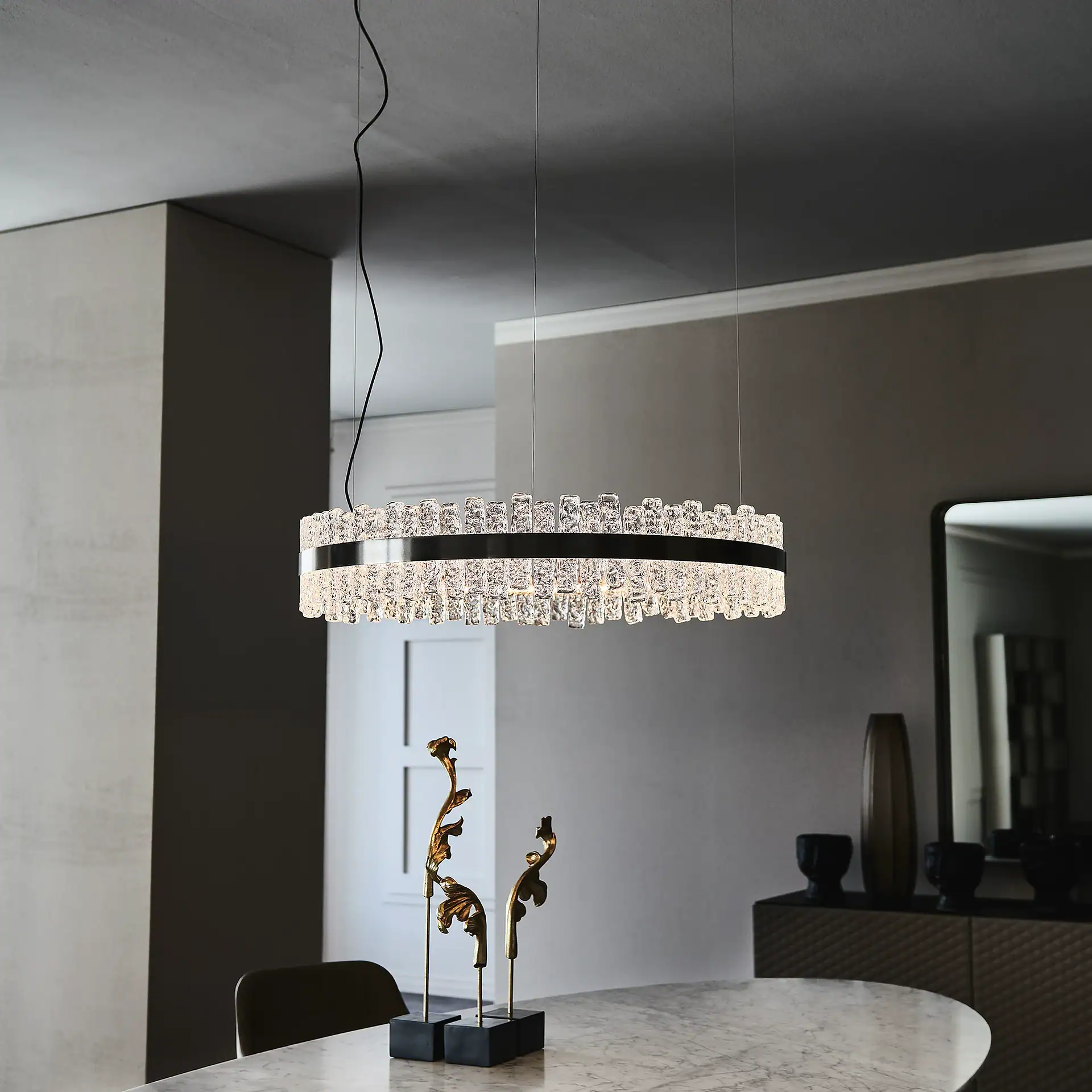Elegant modern crystal chandelier hanging above a dining table in a contemporary interior.