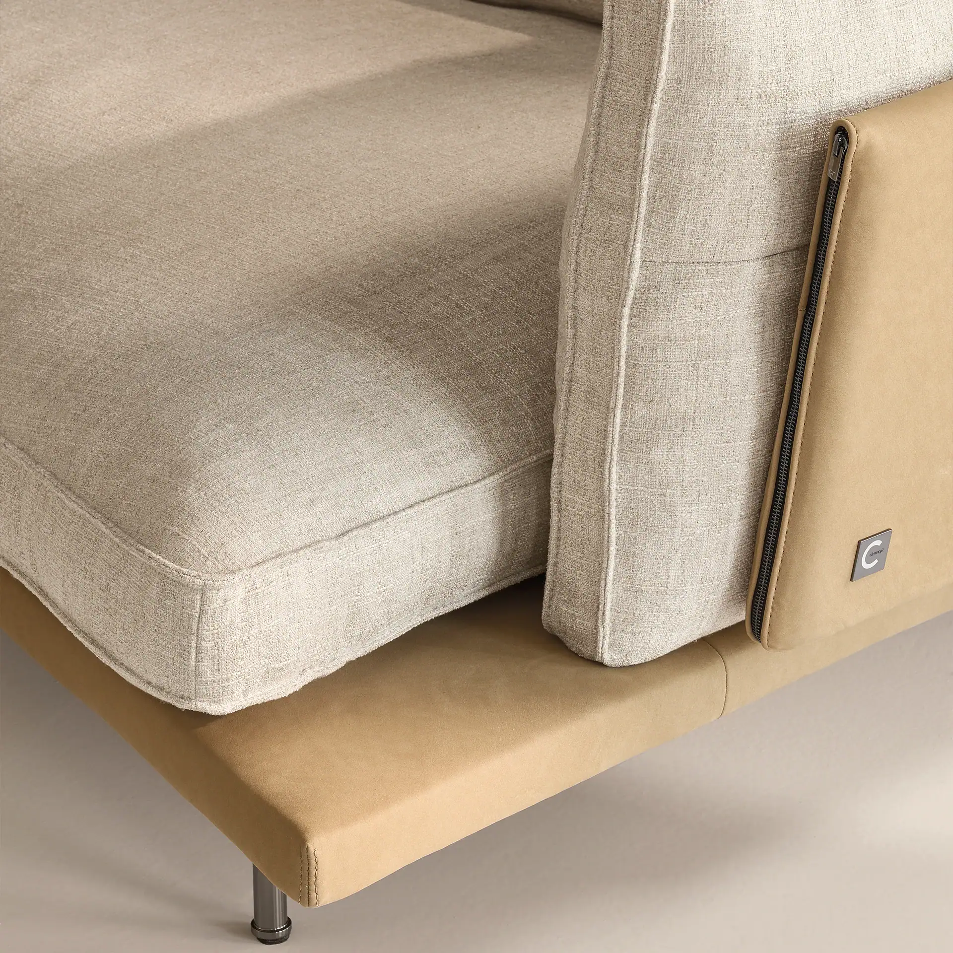 Close-up of a beige modular sectional sofa with a beige base and a beige cushion.