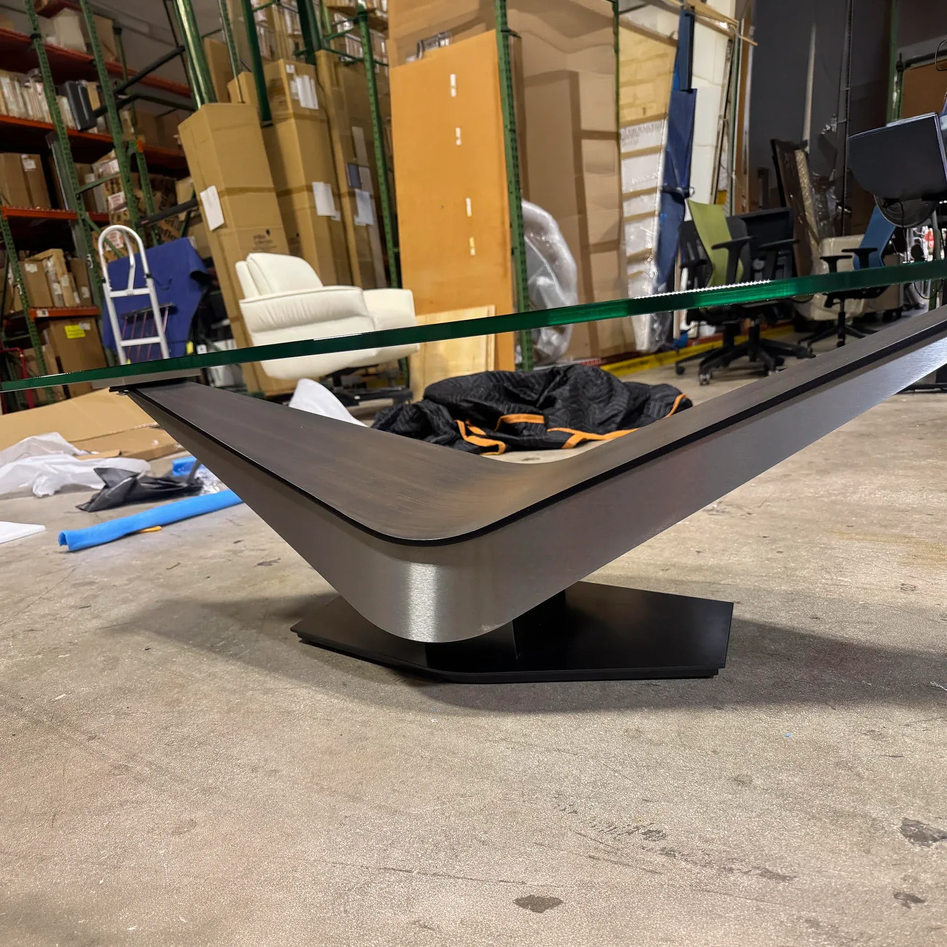 Sklar Furnishings Victor cocktail table with glass top in a warehouse setting.