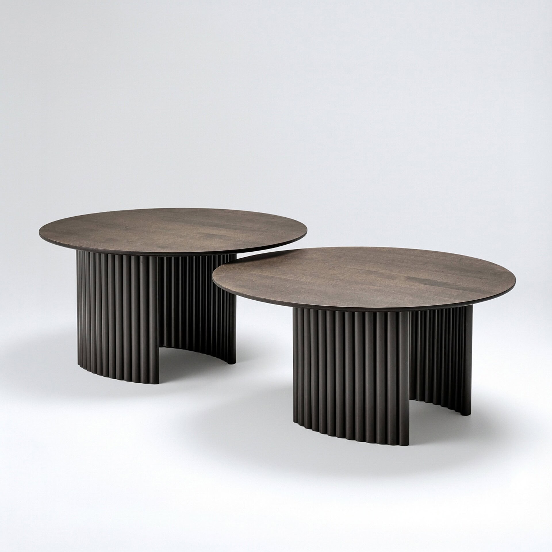 Round cocktail table with a modern design and ribbed black base.