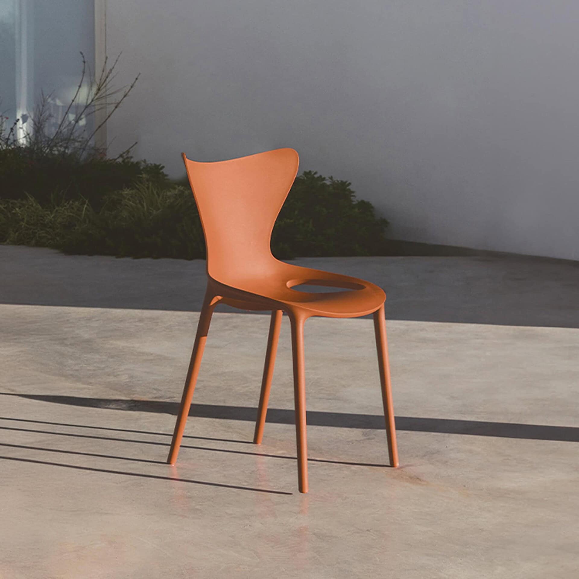 Modern orange outdoor dining chair by Vondom for stylish outdoor spaces.