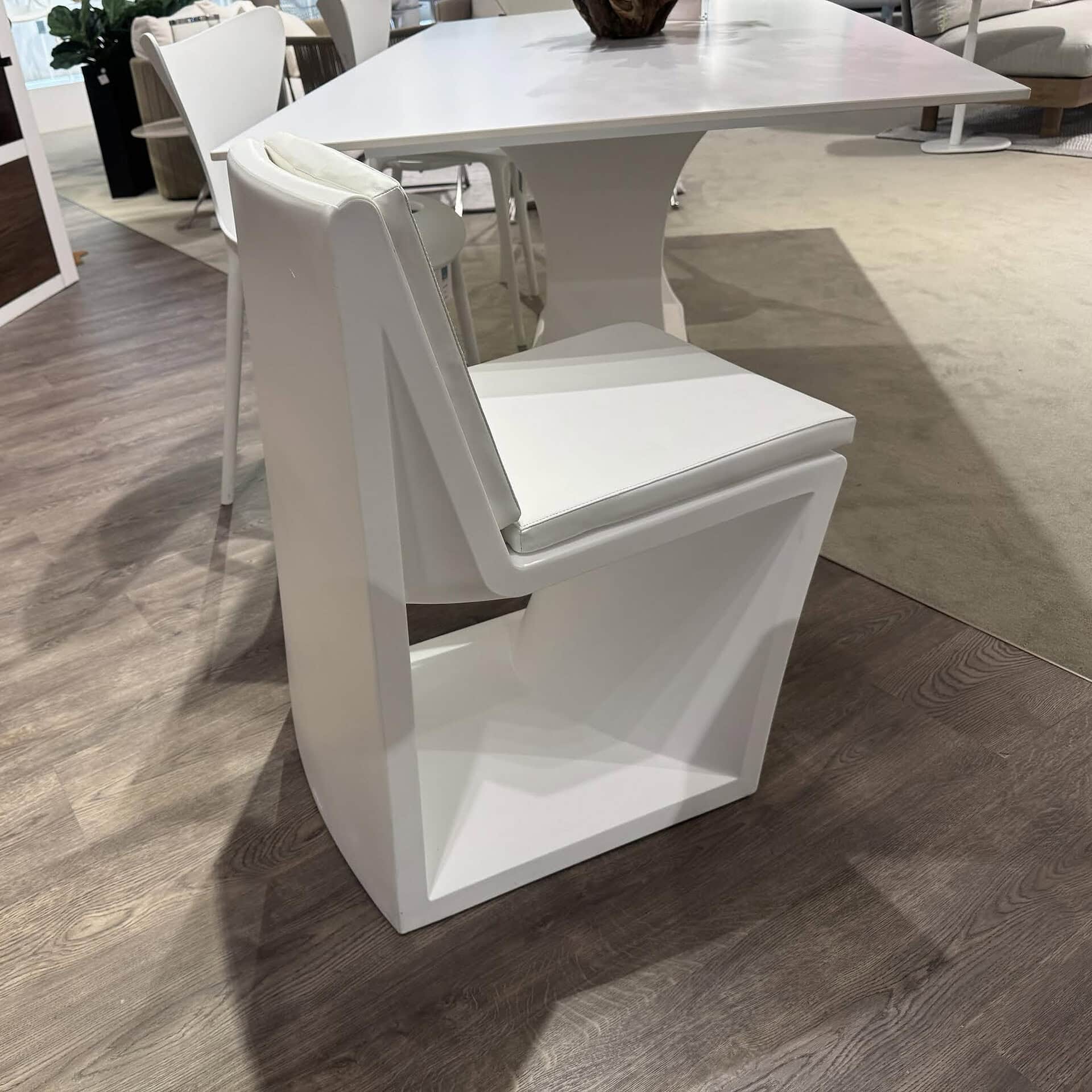 White dining chair with modern style and plush seating for dining rooms.