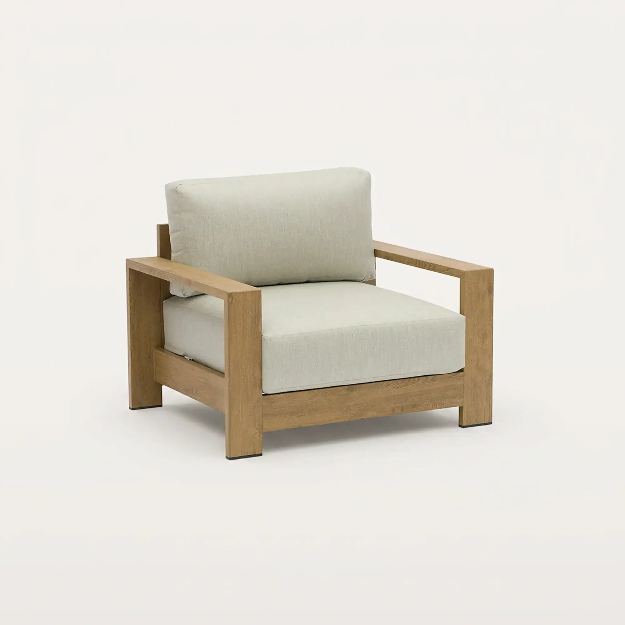 A modern armchair with a light brown wooden frame and light beige cushions on a white background.