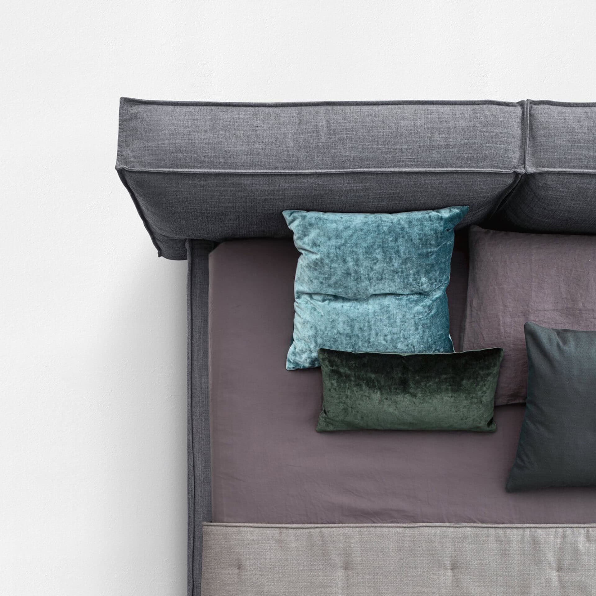 Flann 2.0 upholstered platform bed with colorful cushions for stylish bedroom decor.