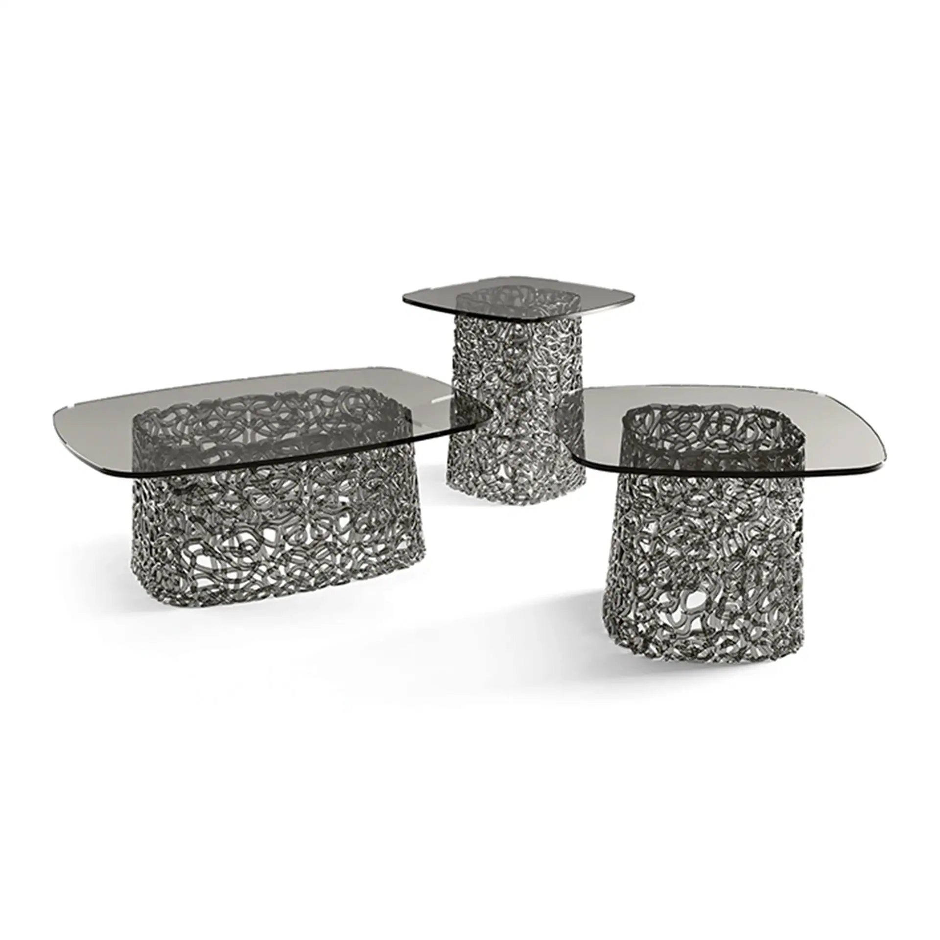 Three modern tables with smoky glass tops and intricate dark metal mesh bases on a white background. One is an oval coffee table, one is a square side table, and one is a rounded rectangular side table.