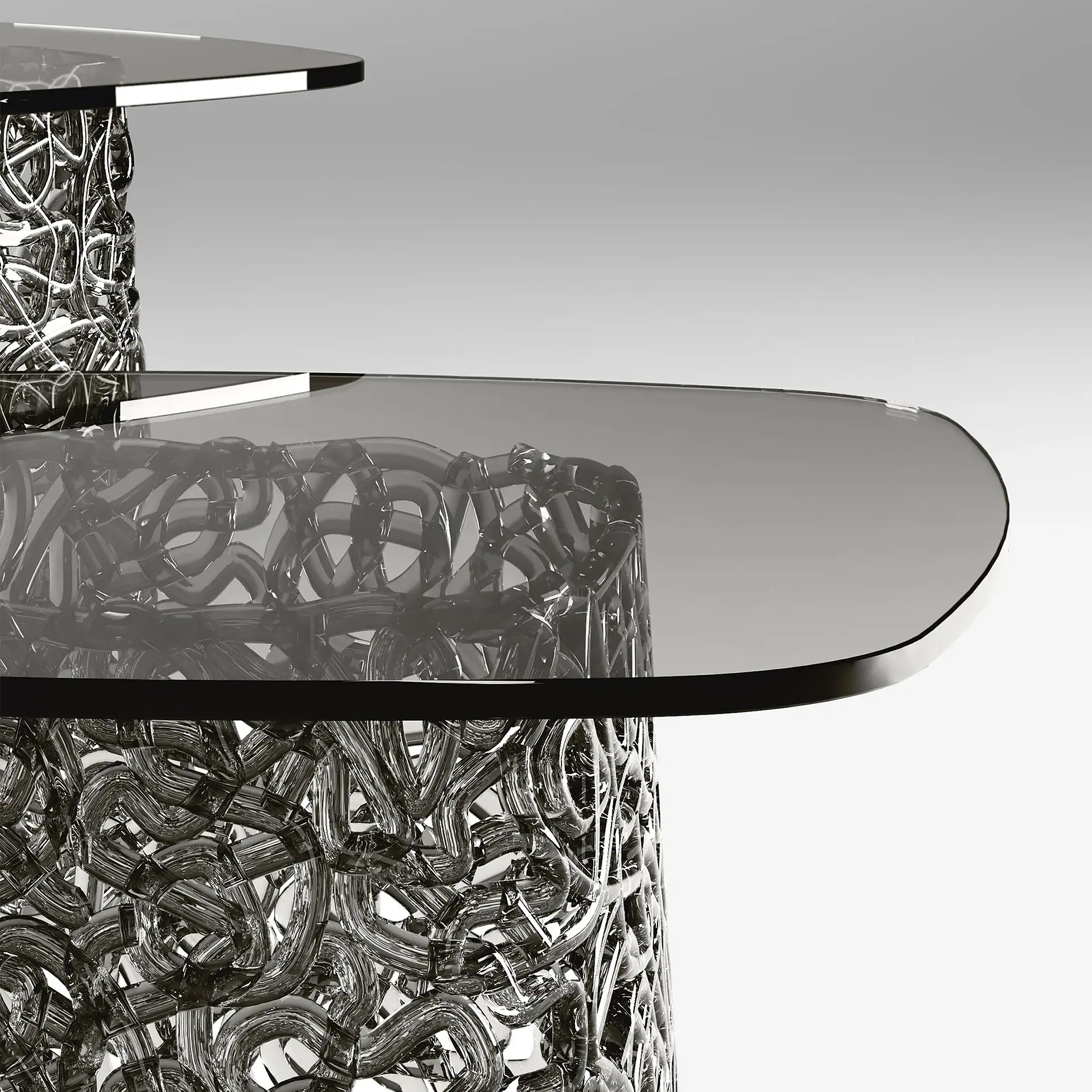 A modern, multi-tiered table with dark smoked glass tops and a highly reflective, intricate chrome base made of interwoven tubular elements.