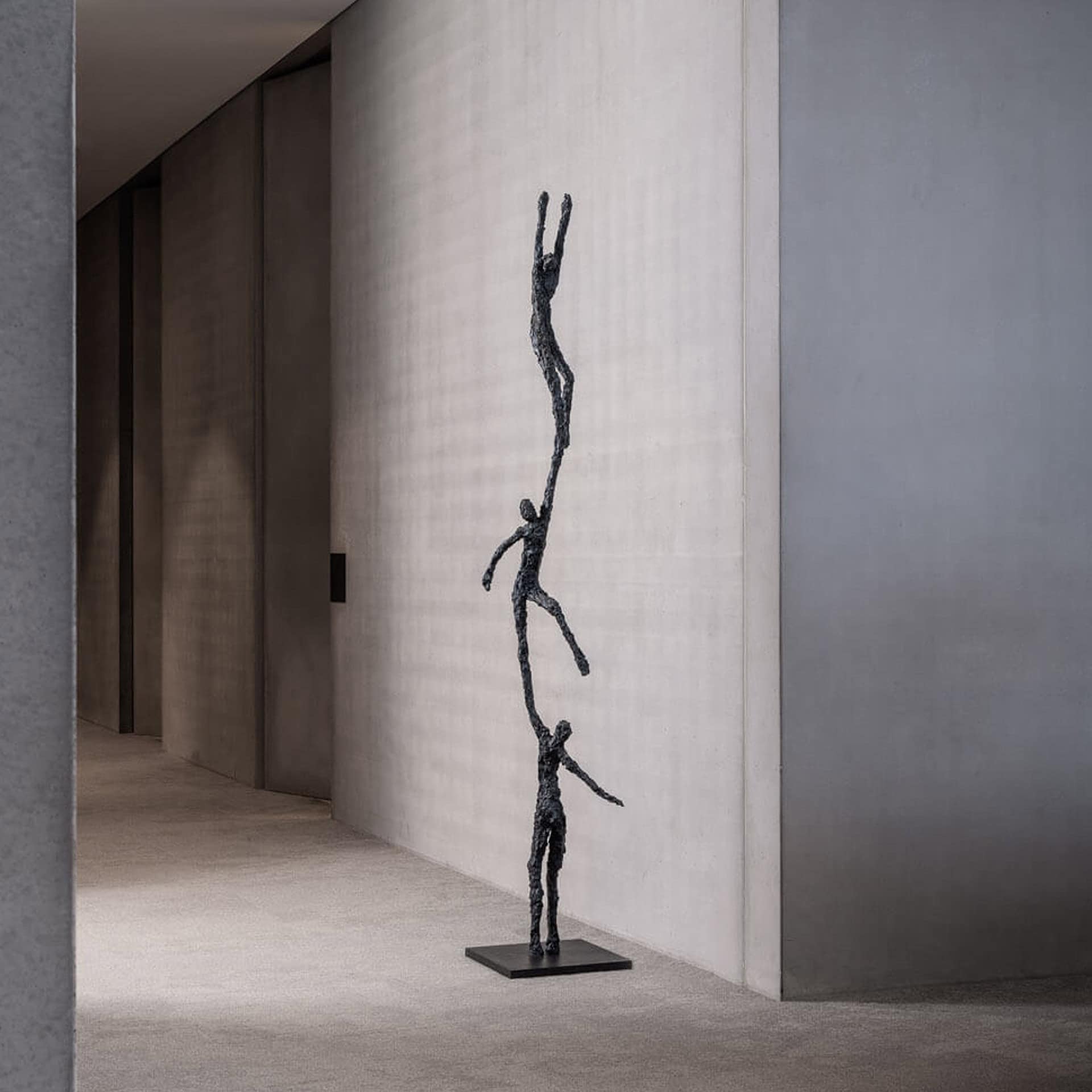 Bronze sculpture titled "To Grab" featuring an elongated, abstract human figure.