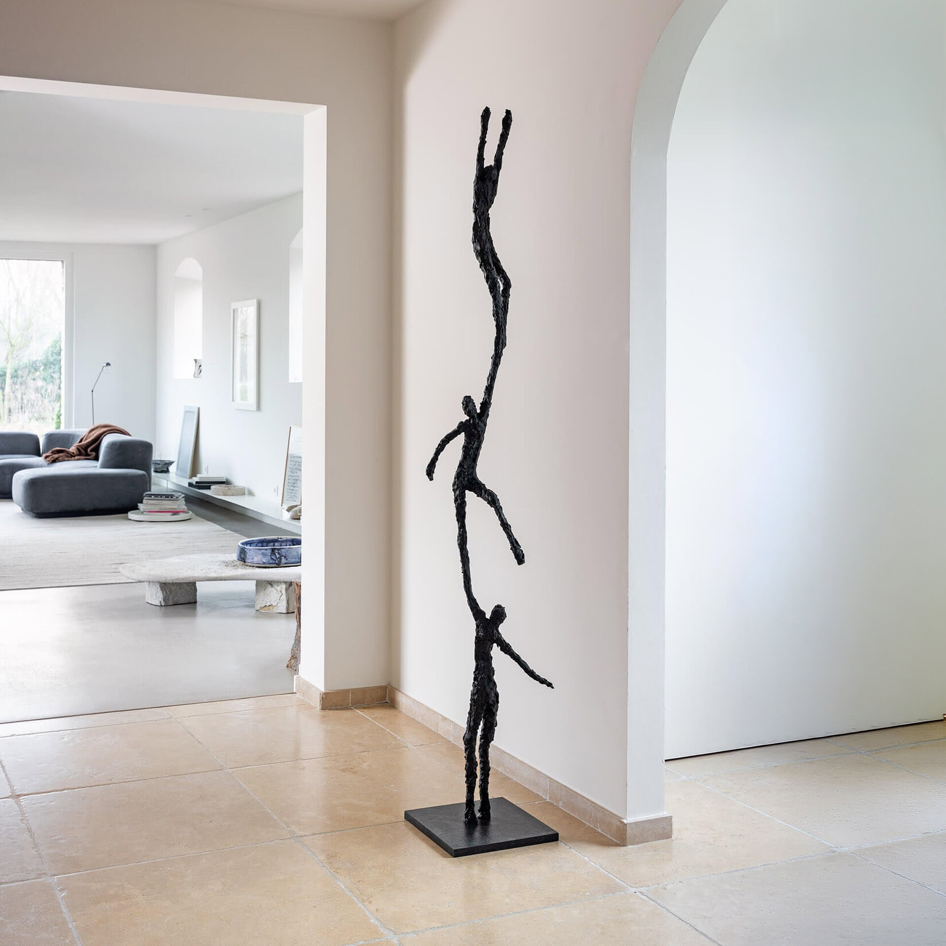 Bronze sculpture titled "To Grab" displayed in a contemporary living space.