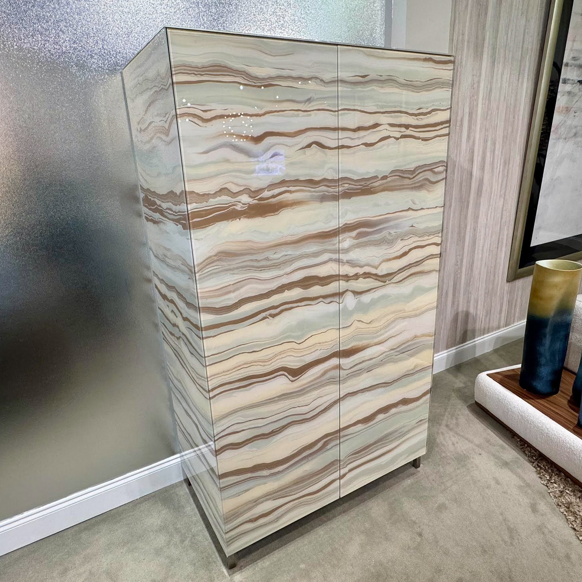 Elegant glass bar cabinet with a marble-like finish for stylish home bar storage.