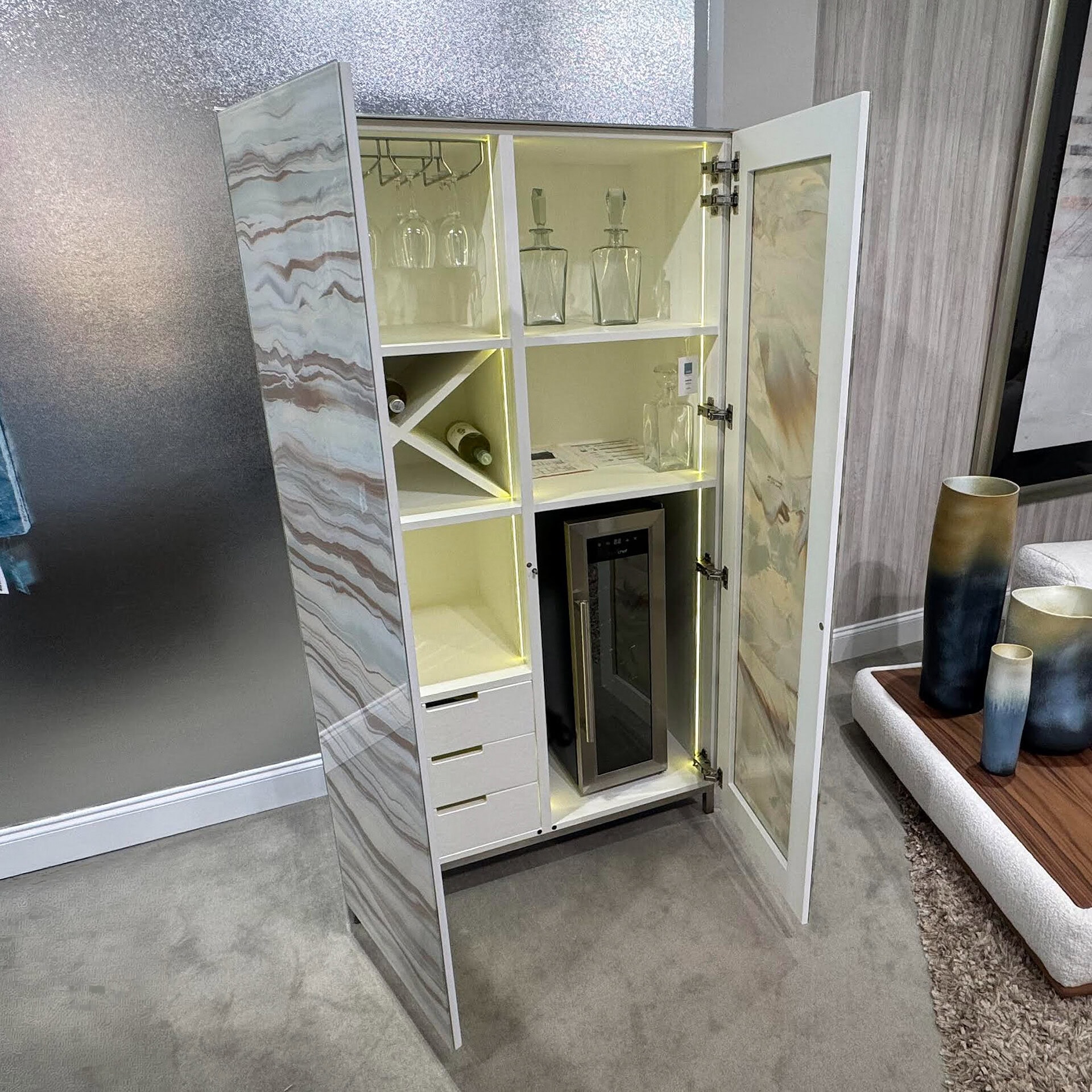 Elegant glass and marble bar cabinet with storage and wine glass racks.