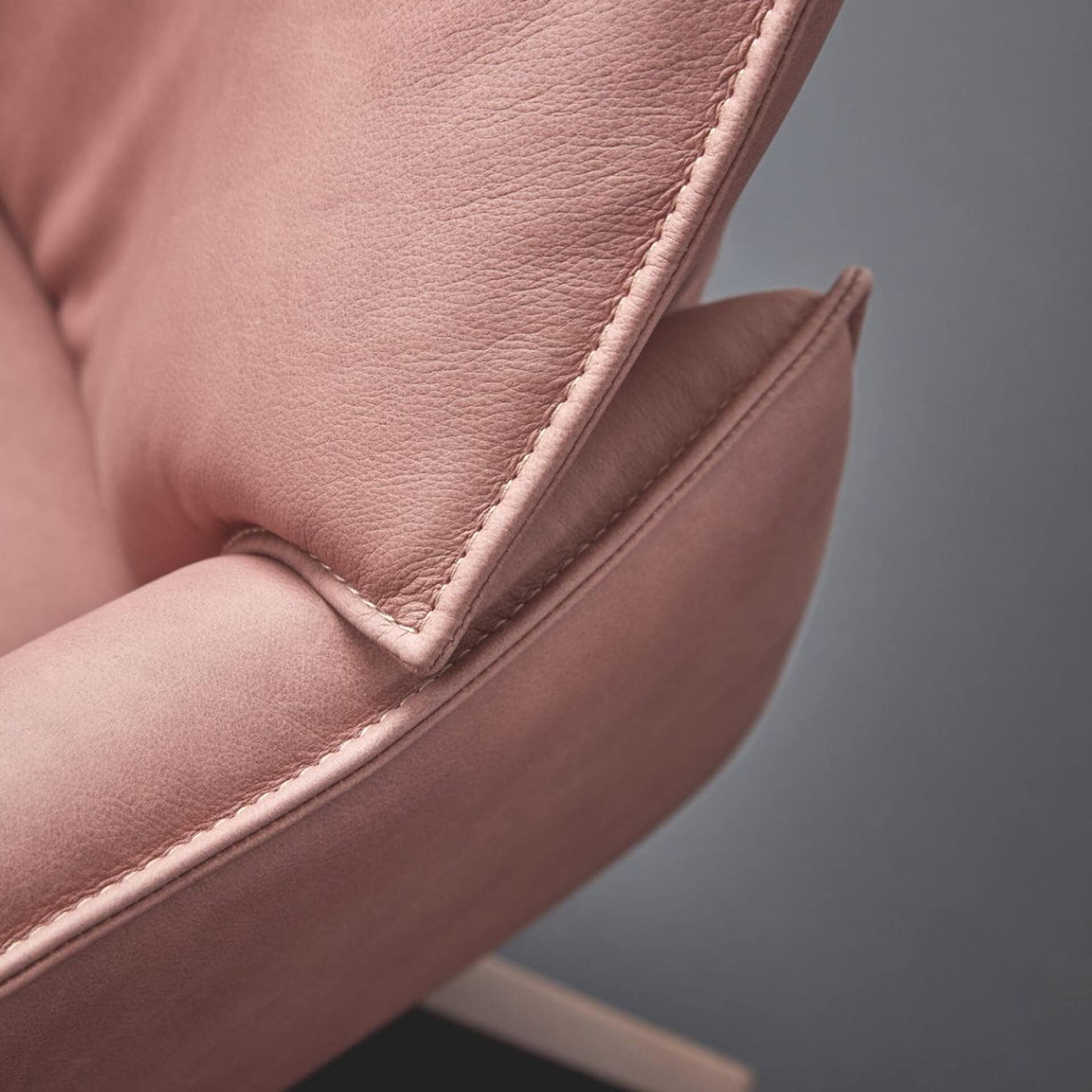 Recliner chair in soft pink upholstery, perfect for relaxing and adding elegance to your living spac.
