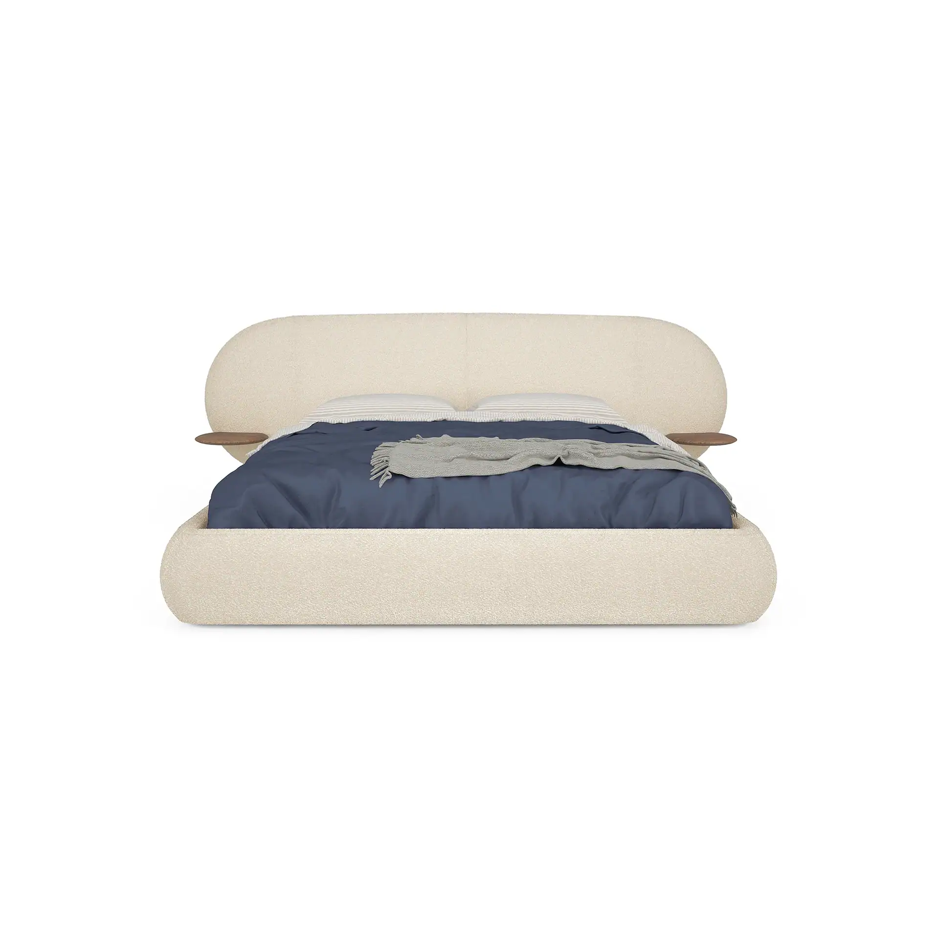 A modern bed with a rounded beige boucle frame and headboard, integrated wooden side shelves, dark blue bedding, and a gray throw blanket, on a white background.