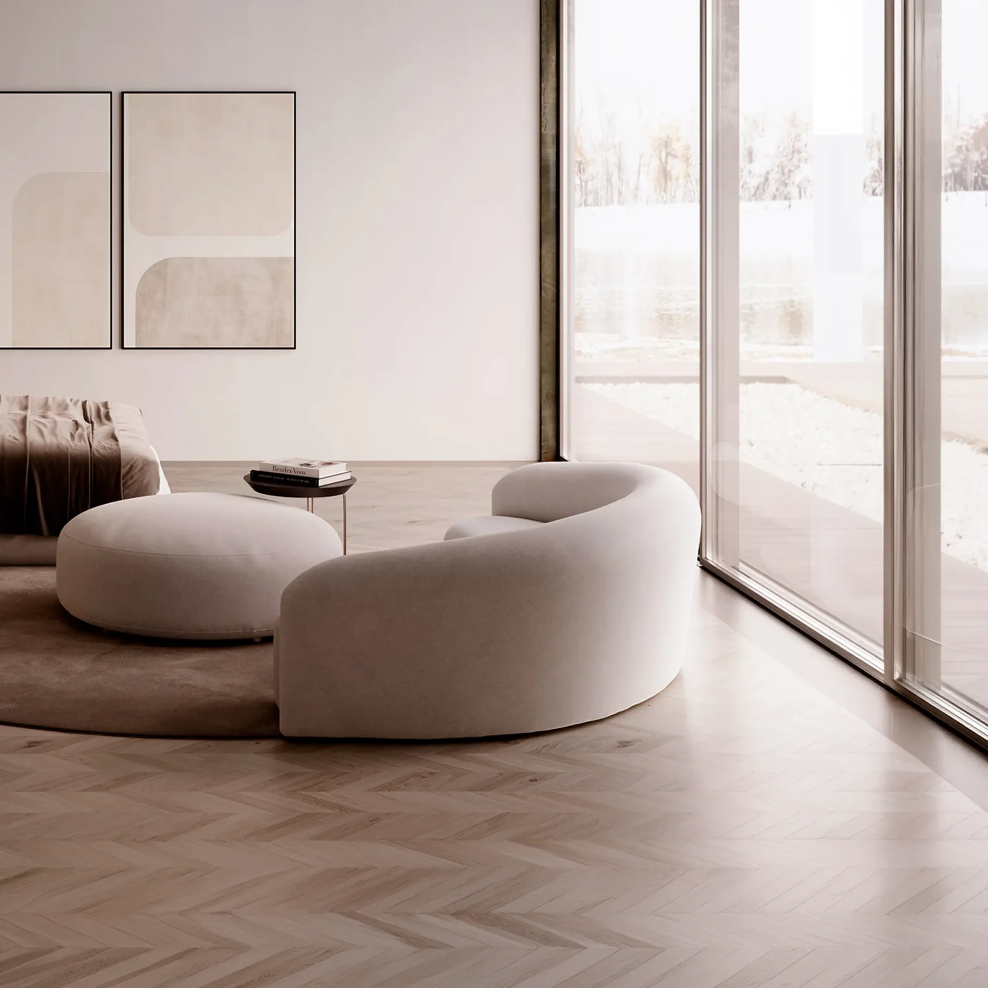 A minimalist living room with a light curved sofa, round ottoman, and abstract art, facing large windows overlooking a bright, possibly snowy, outdoor landscape.