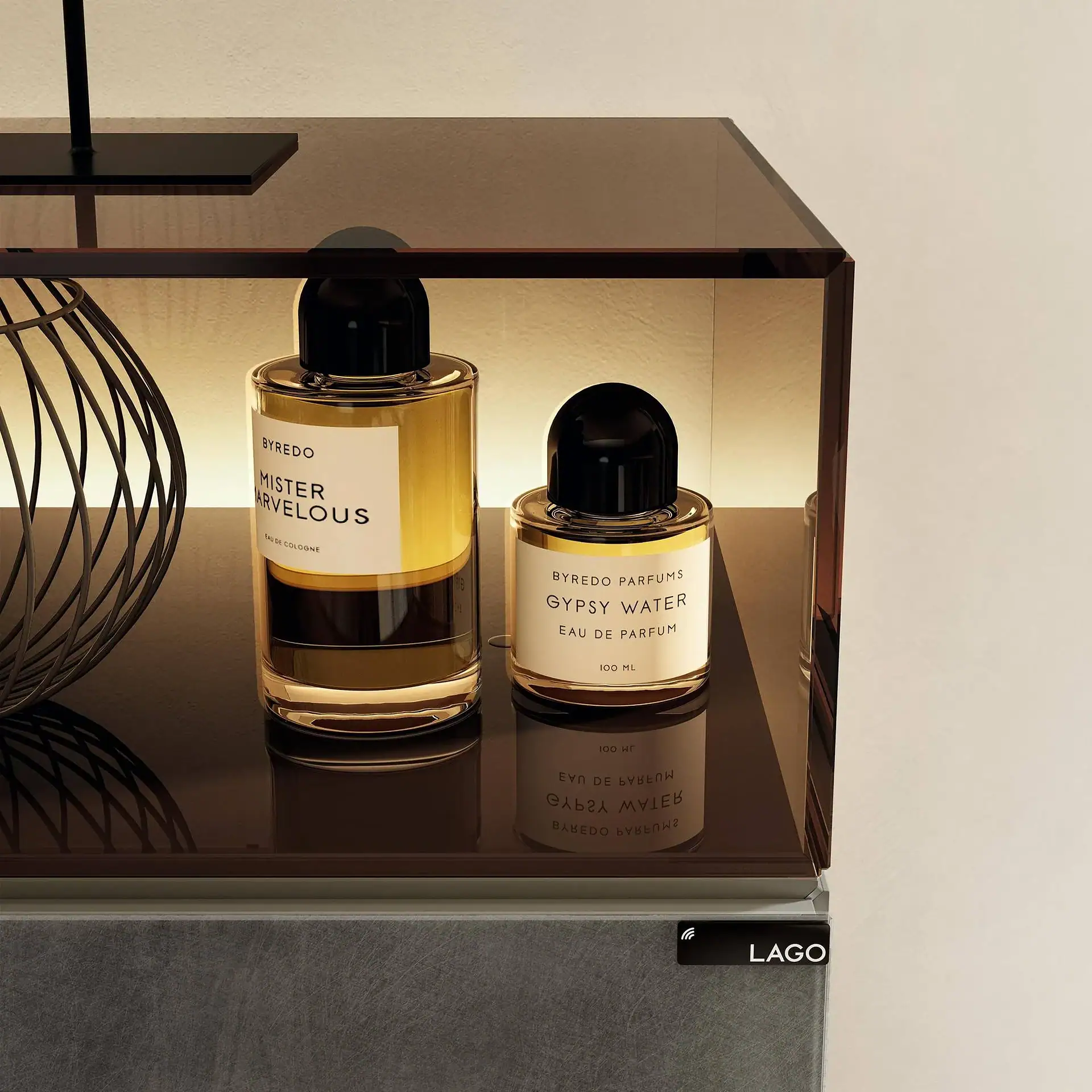 Two Byredo perfume bottles, Mister Marvellous and Gypsy Water, on a dark, reflective shelf with a decorative sphere.