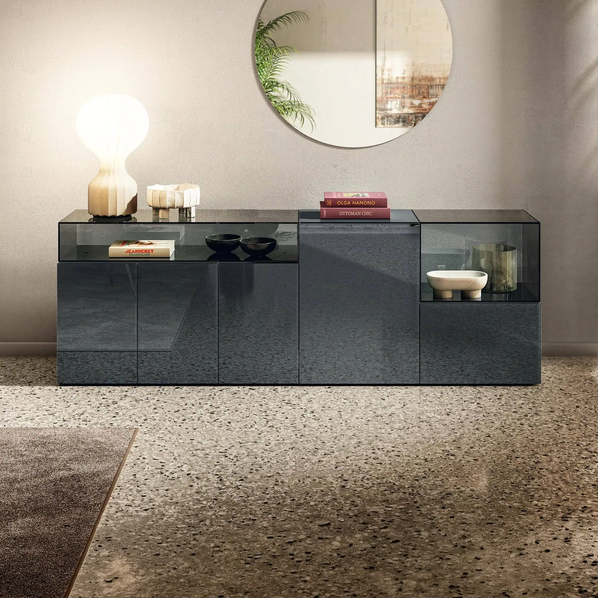 Sklar Furnishings glass sideboard with decorative items and books.