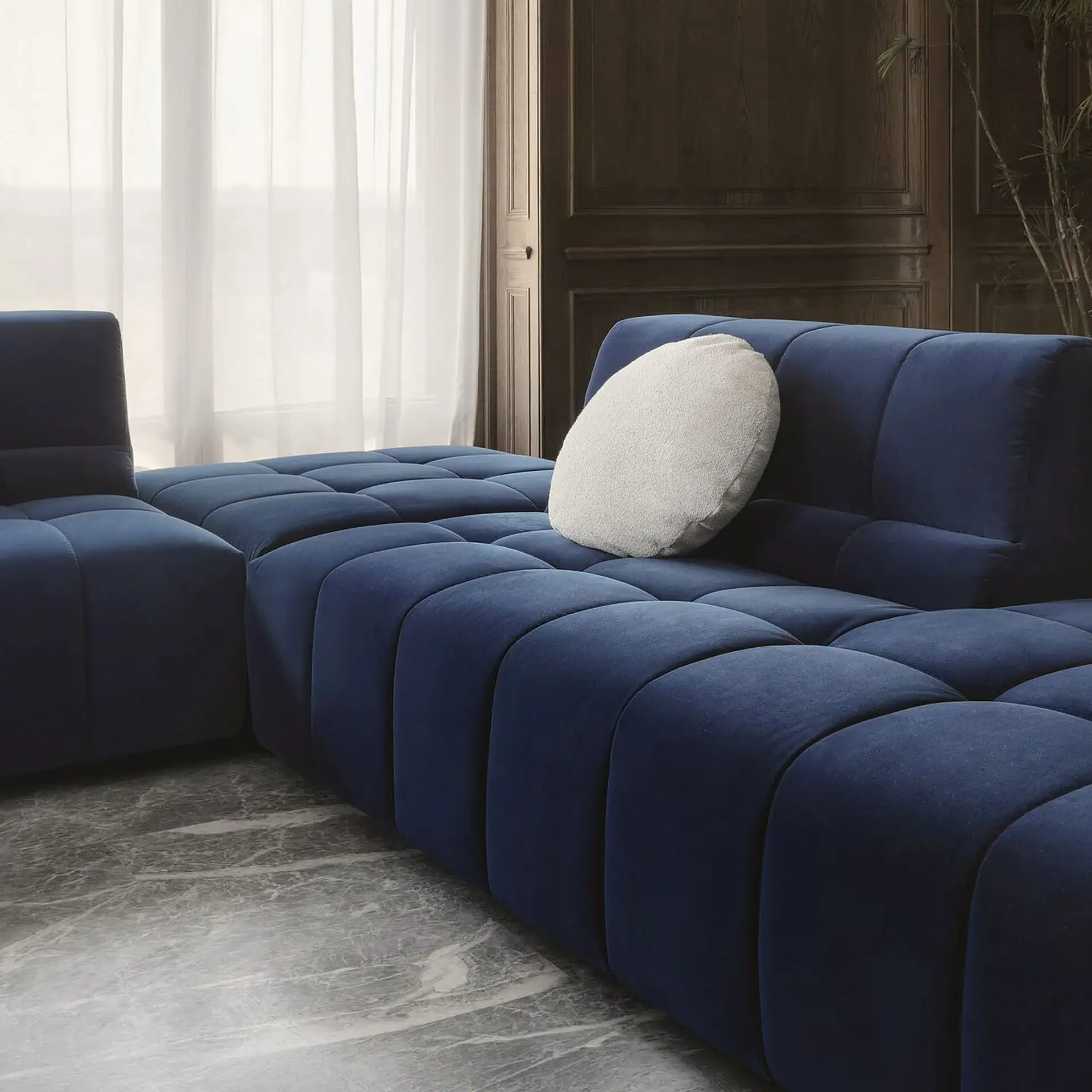 Navy blue sectional sofa with plush cushions, perfect for contemporary living room decor.