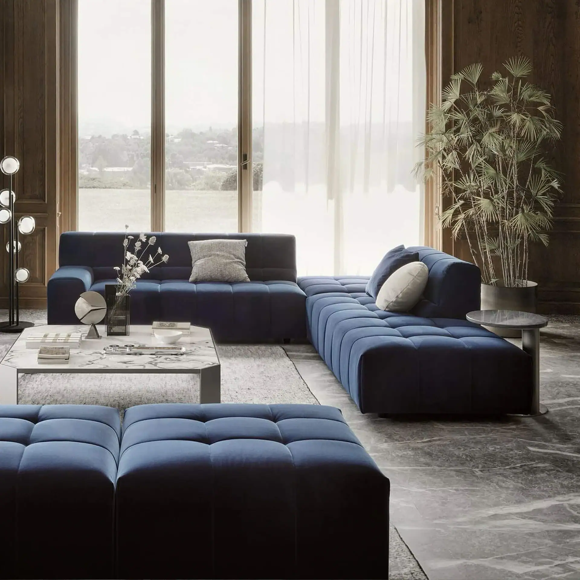 Navy blue sectional sofa in a contemporary living room with large windows and natural lighting.