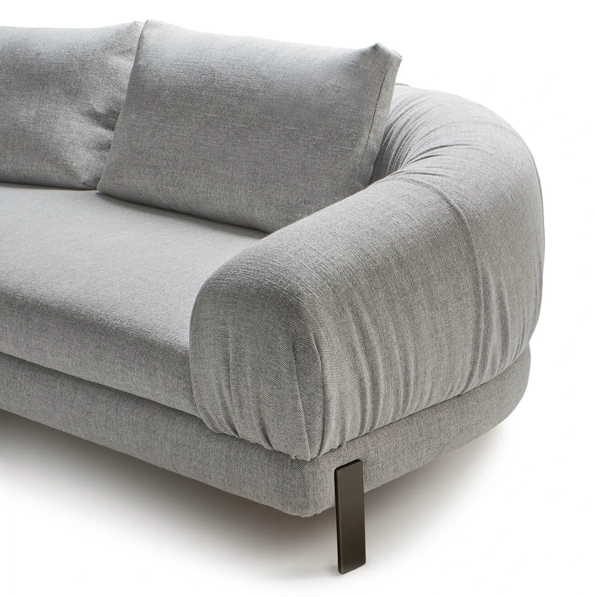 Close-up of a modern grey sofa with textured fabric, rounded armrest, and a dark rectangular leg, against a white background.