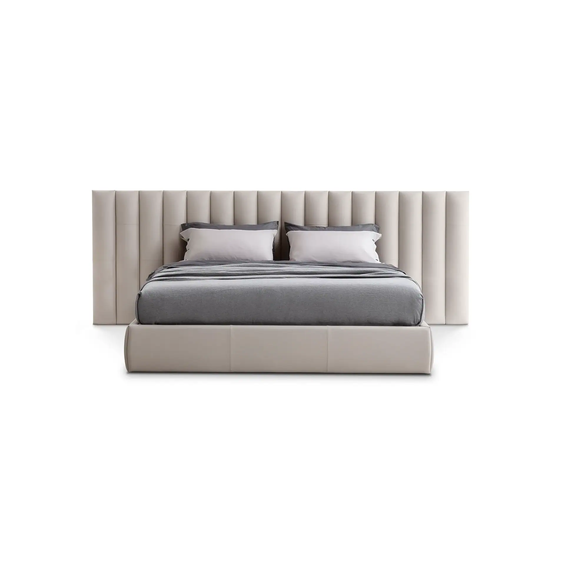 A modern bed with a cream channel tufted headboard and matching upholstered frame, dressed with grey and white bedding.