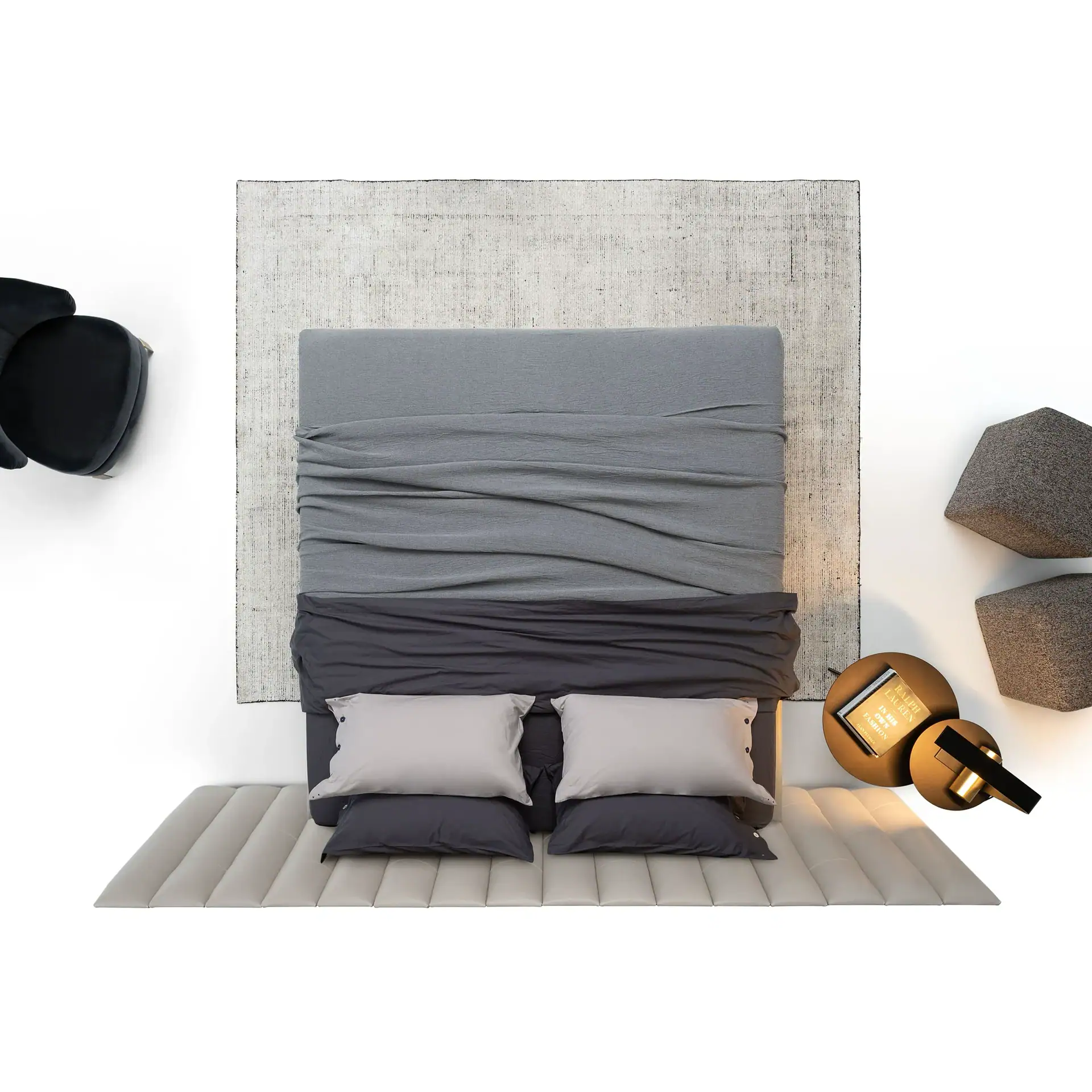 Overhead view of a modern bedroom with a gray fabric bed, light gray rug, dark and light gray pillows, round side tables with a book and lamp, and two geometric poufs, all on a white background.