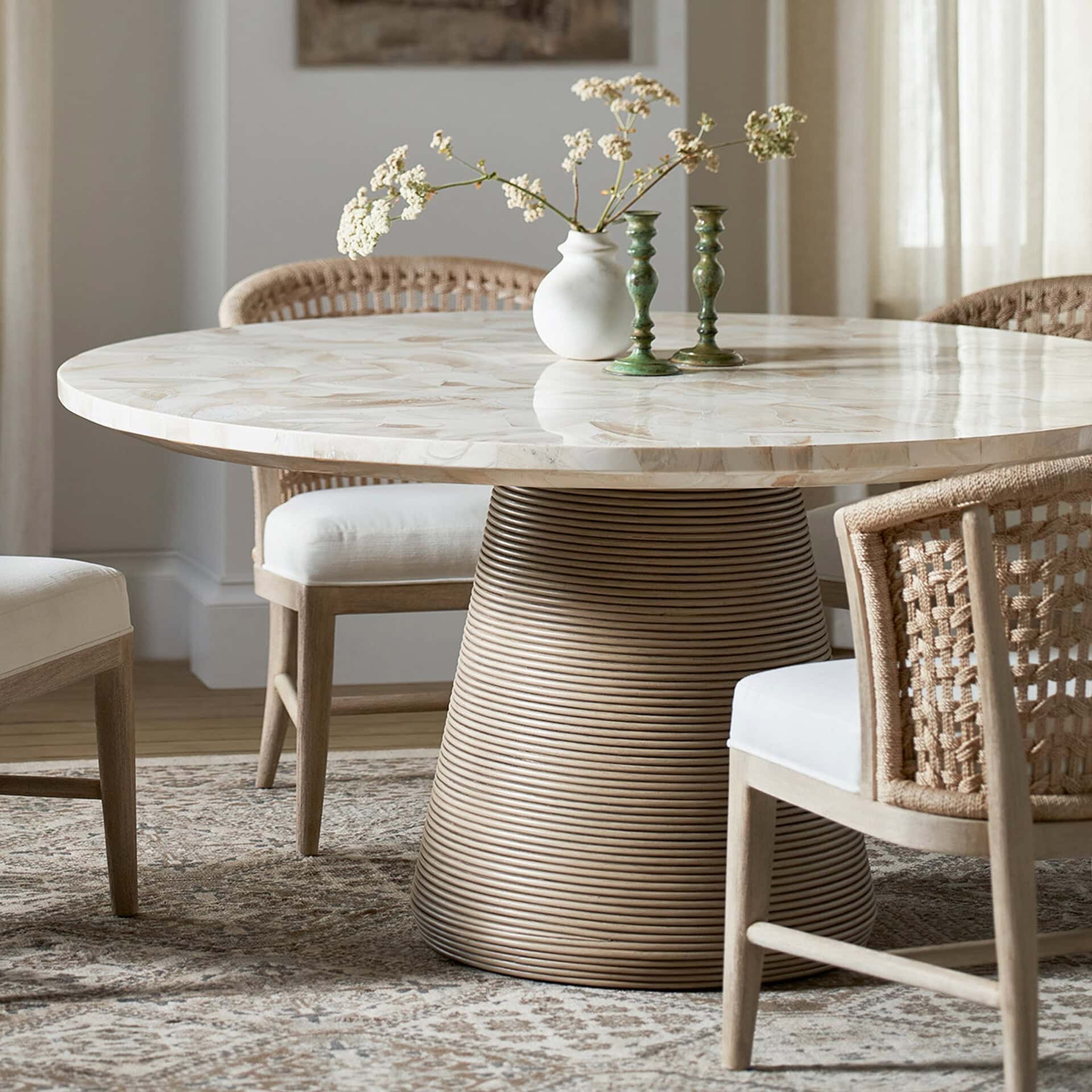 Elegant Stinson round dining table with a marble top and unique striped base. Perfect for modern and.