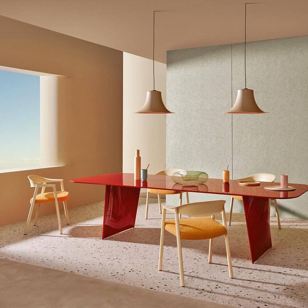 Stylish dining table with vibrant chairs and pendant lighting, perfect for contemporary home decor.