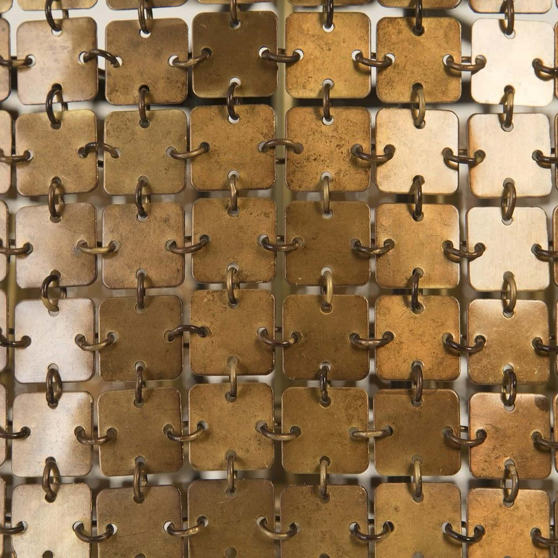 Close-up of a brass chandelier with interconnected square and ring design.