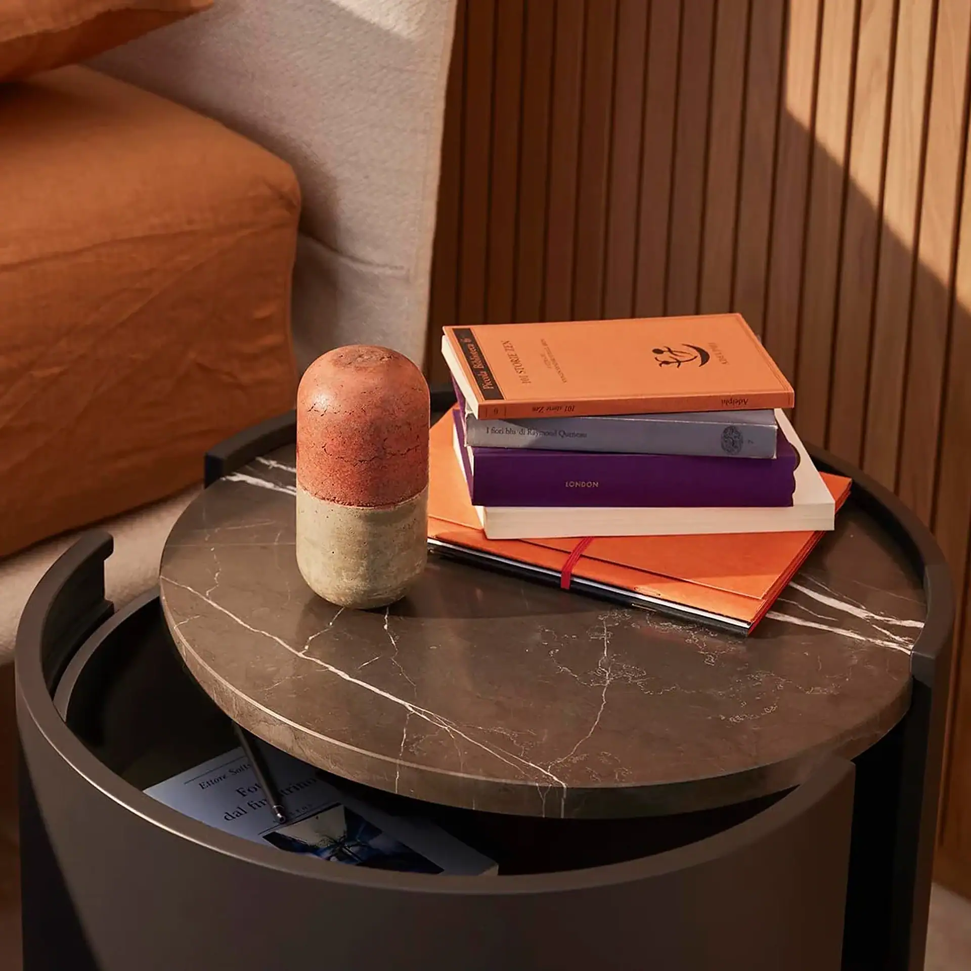 Sklar Furnishings nightstand with books and decorative vase.