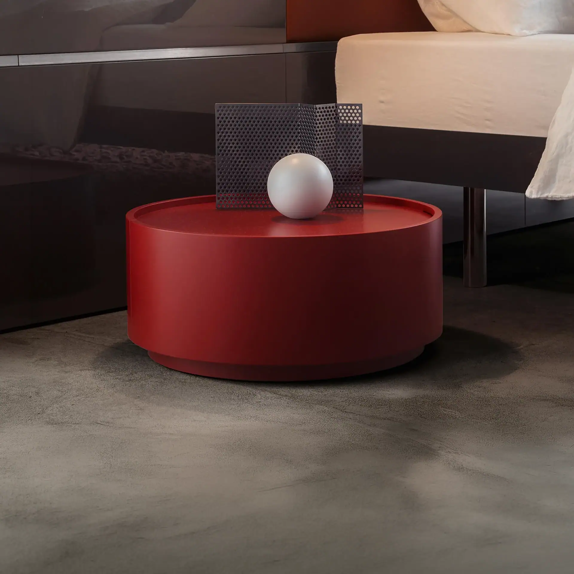 Red round side table with decorative objects on top in a contemporary room.