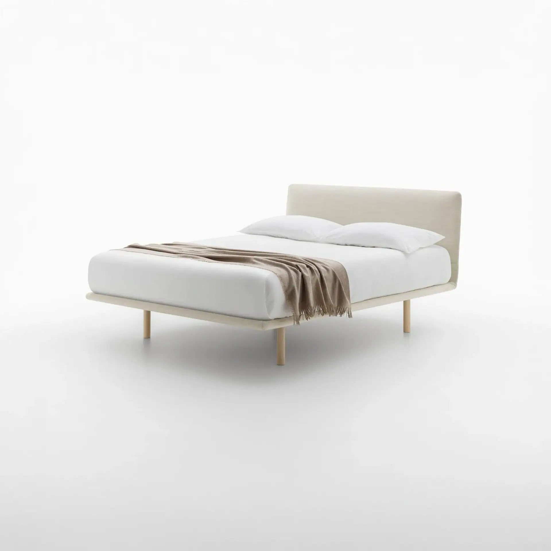 A modern bed with a light beige upholstered frame and headboard, white bedding, and a brown throw blanket, on a white background.