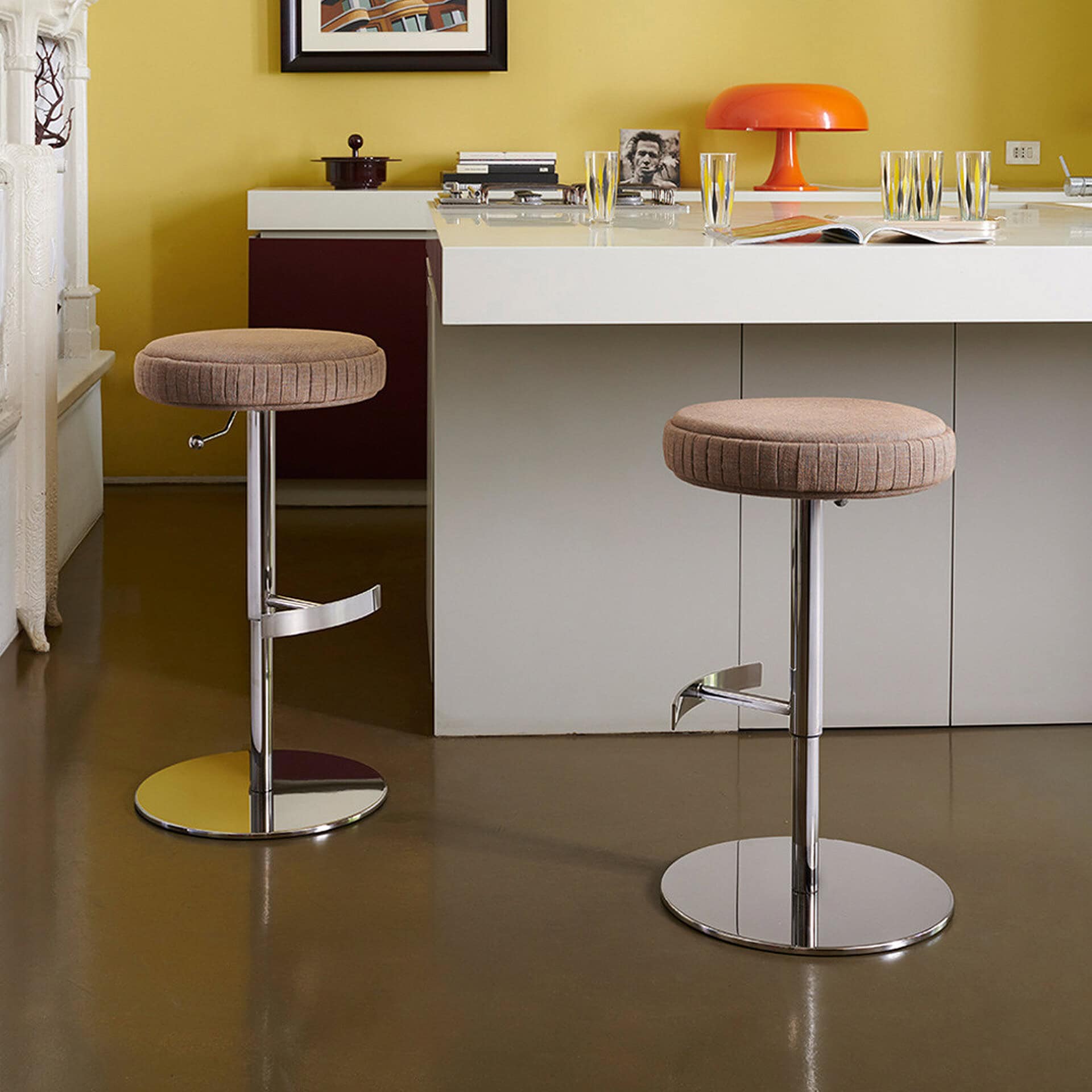 Adjustable plissé upholstered stools in modern kitchen setting.