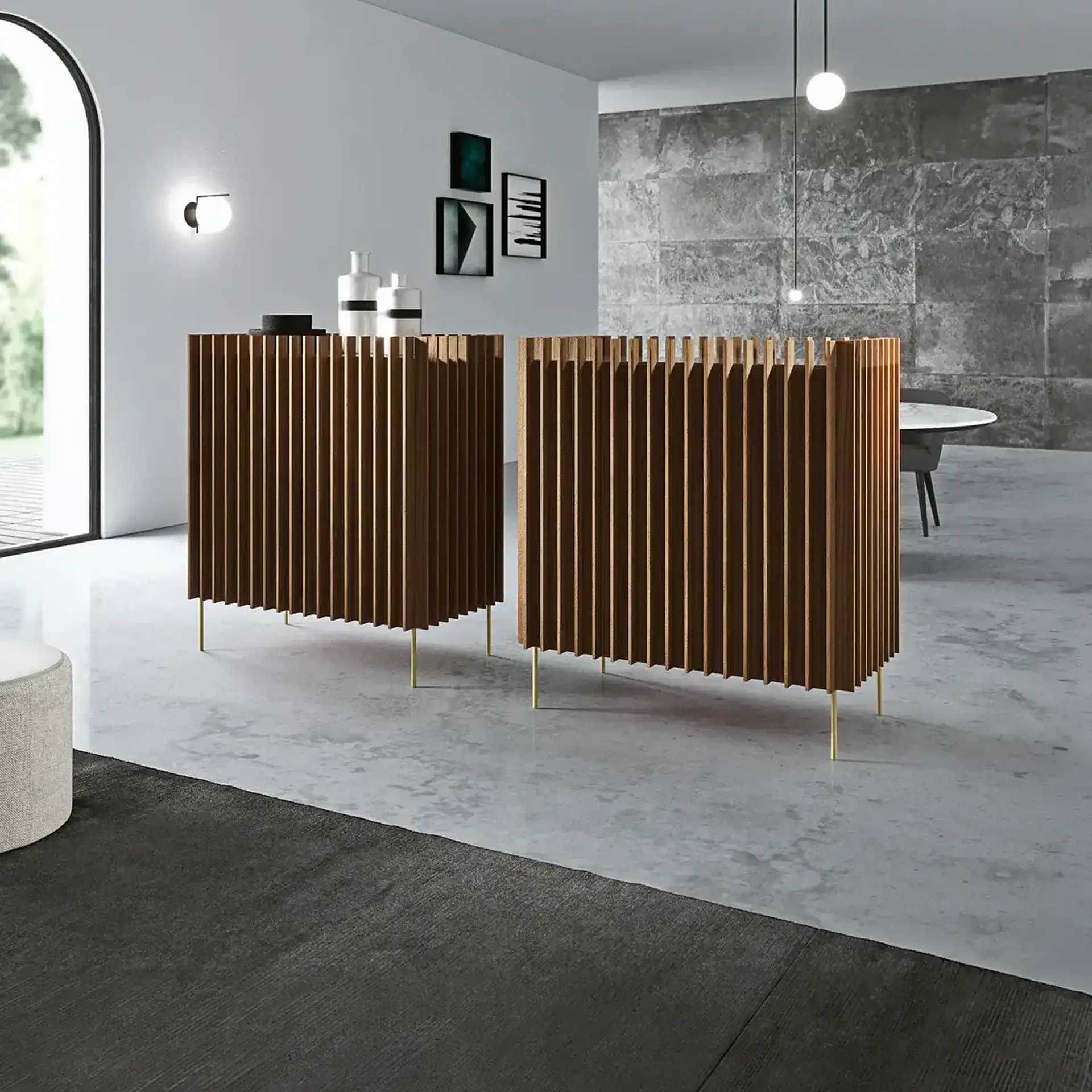 Two slatted wooden cabinets with golden legs in a modern room. The room has light gray walls, a textured stone wall, an arched window, and minimalist decor.