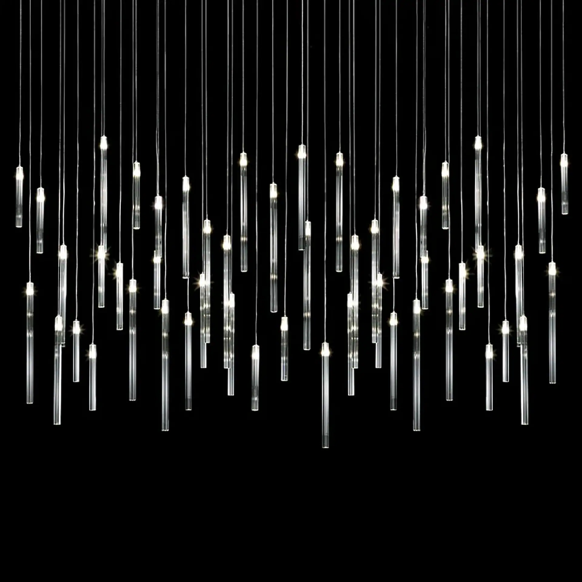 Comete Crystal Chandelier with hanging glass rods and lights against black background.