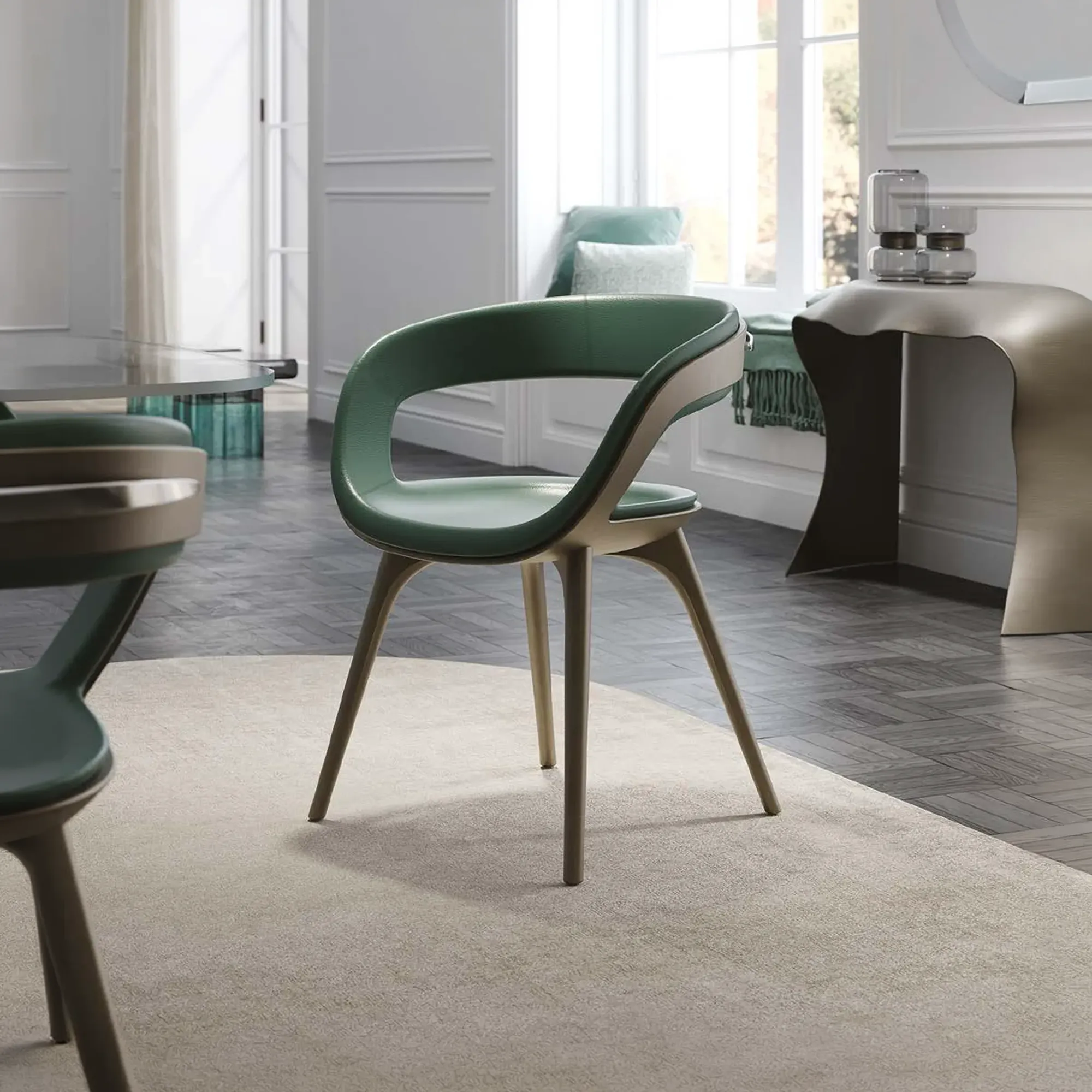 A modern dining chair with green upholstery and light brown wooden legs sits on a beige rug in a bright room with a window and dining table.