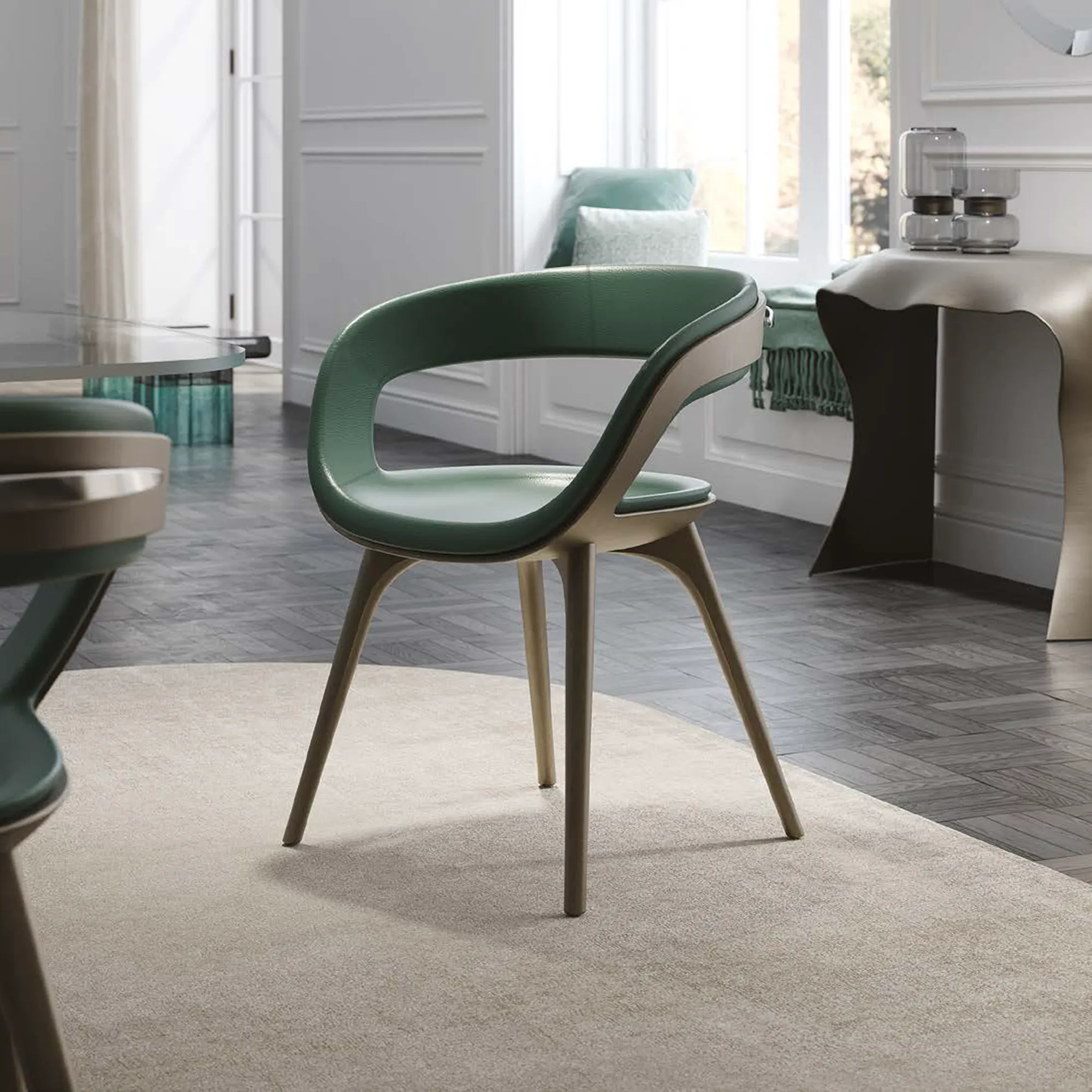 A modern dining chair with green upholstery and light brown wooden legs sits on a beige rug in a bright room with a window and dining table.