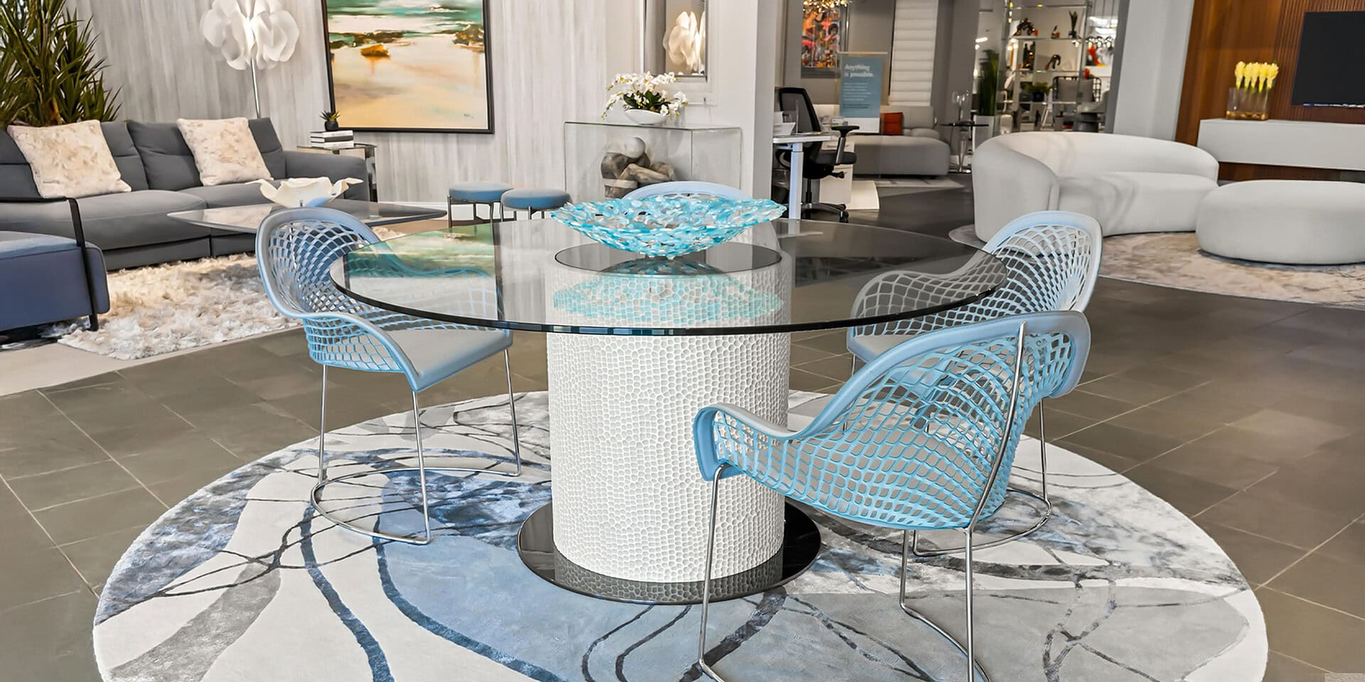 Stylish glass dining table with blue woven chairs in contemporary living space.