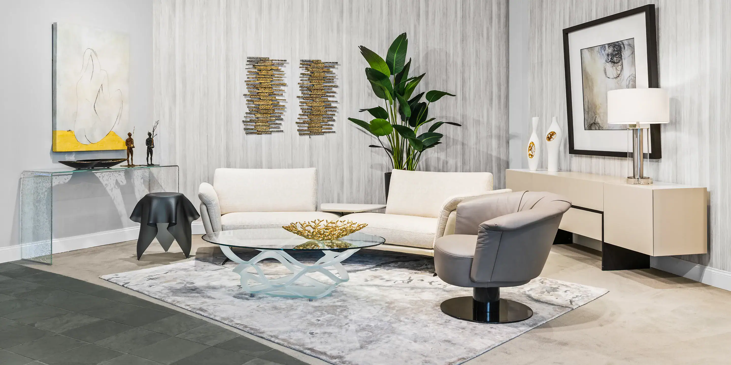 Elegant living room featuring contemporary sofas, a glass coffee table, and stylish decor accents. P.