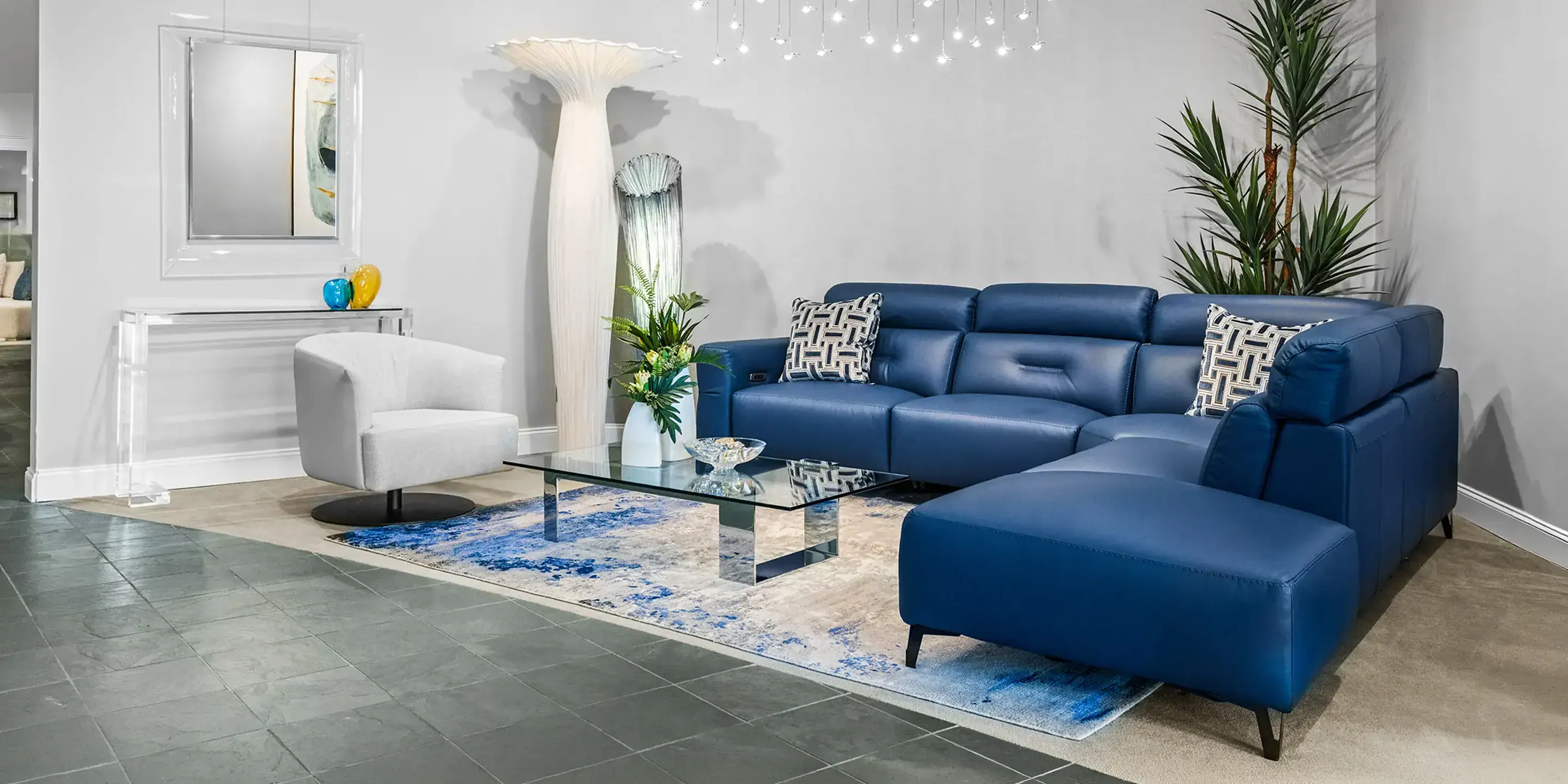 showroom-vignette-jun-25-living-room Stylish blue sectional sofa with matching ottoman in contemporary living space.