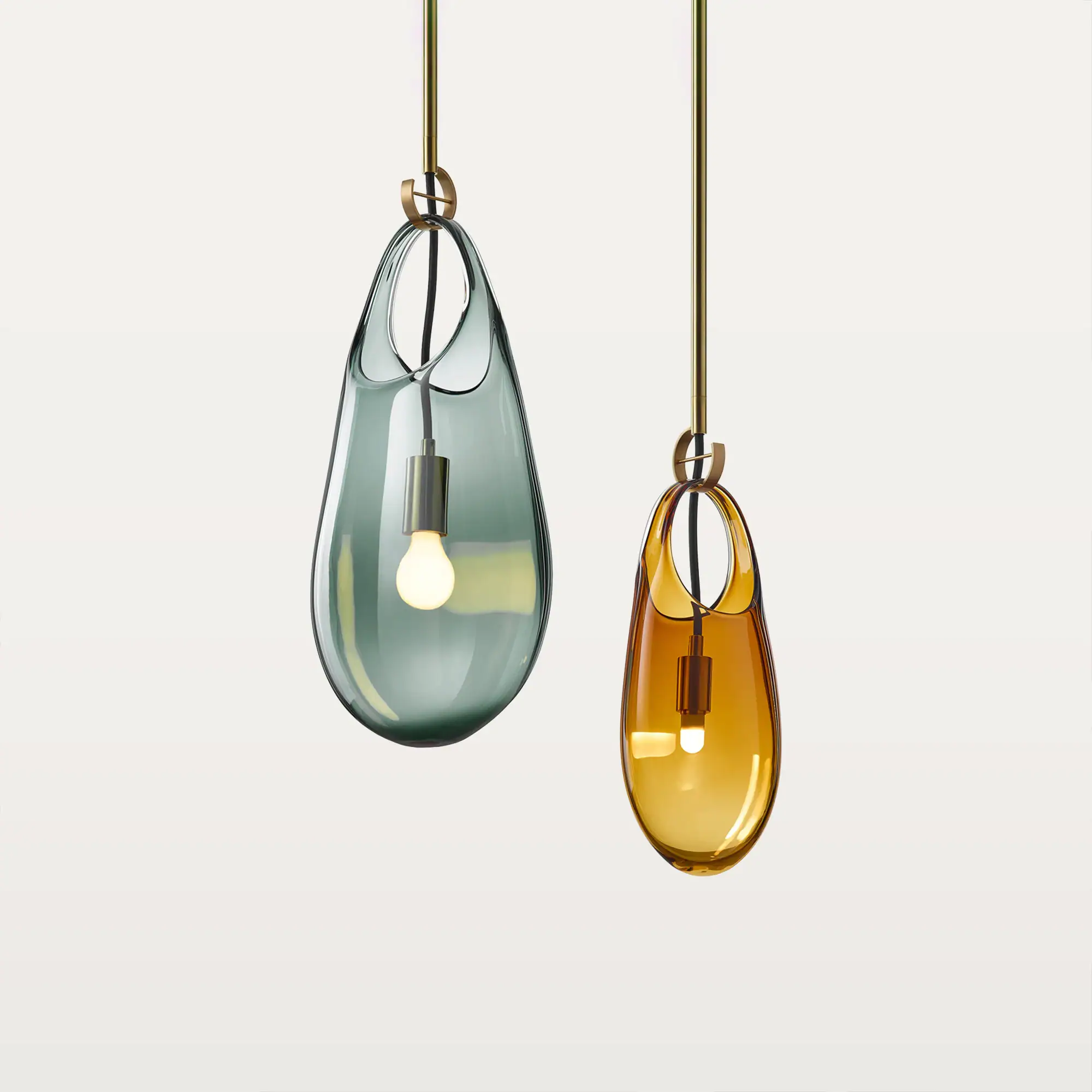 Two modern pendant lights with teardrop-shaped glass shades. One is teal, the other amber, both suspended by brass rods with glowing bulbs inside.