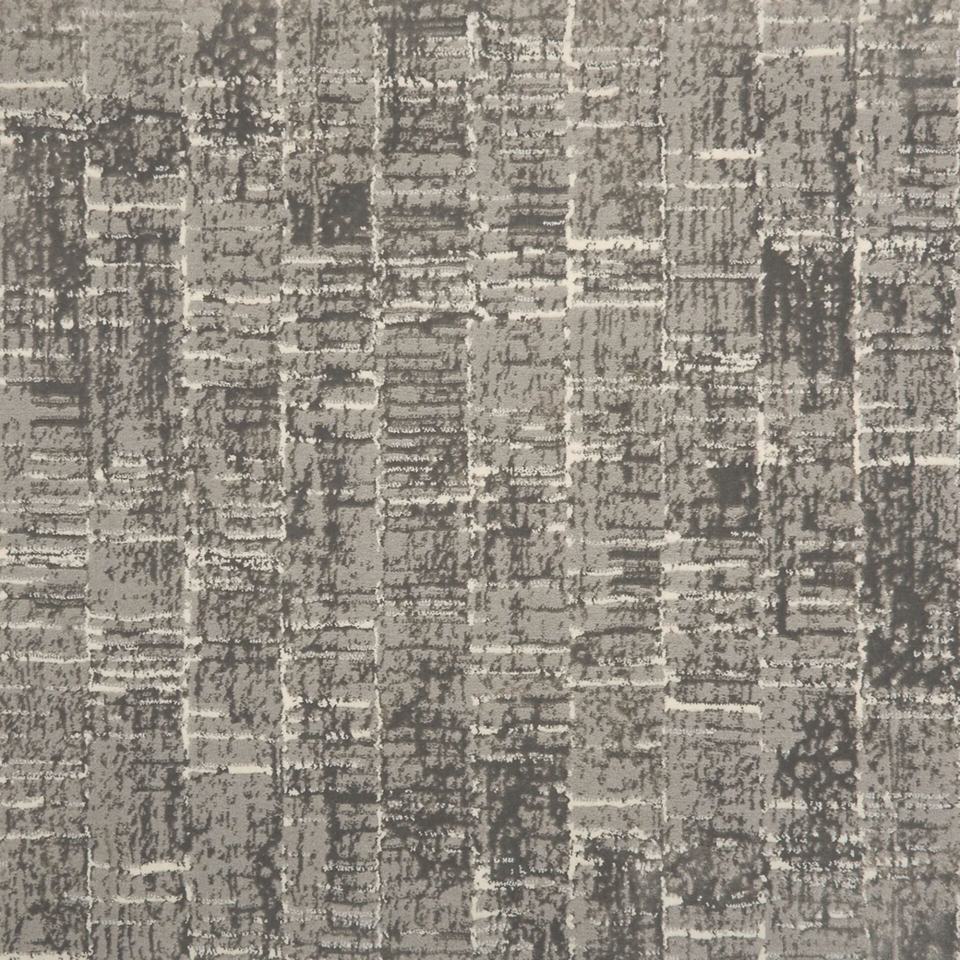 Close-up of a textured gray fabric or carpet with an abstract, irregular grid pattern in light and dark gray tones.