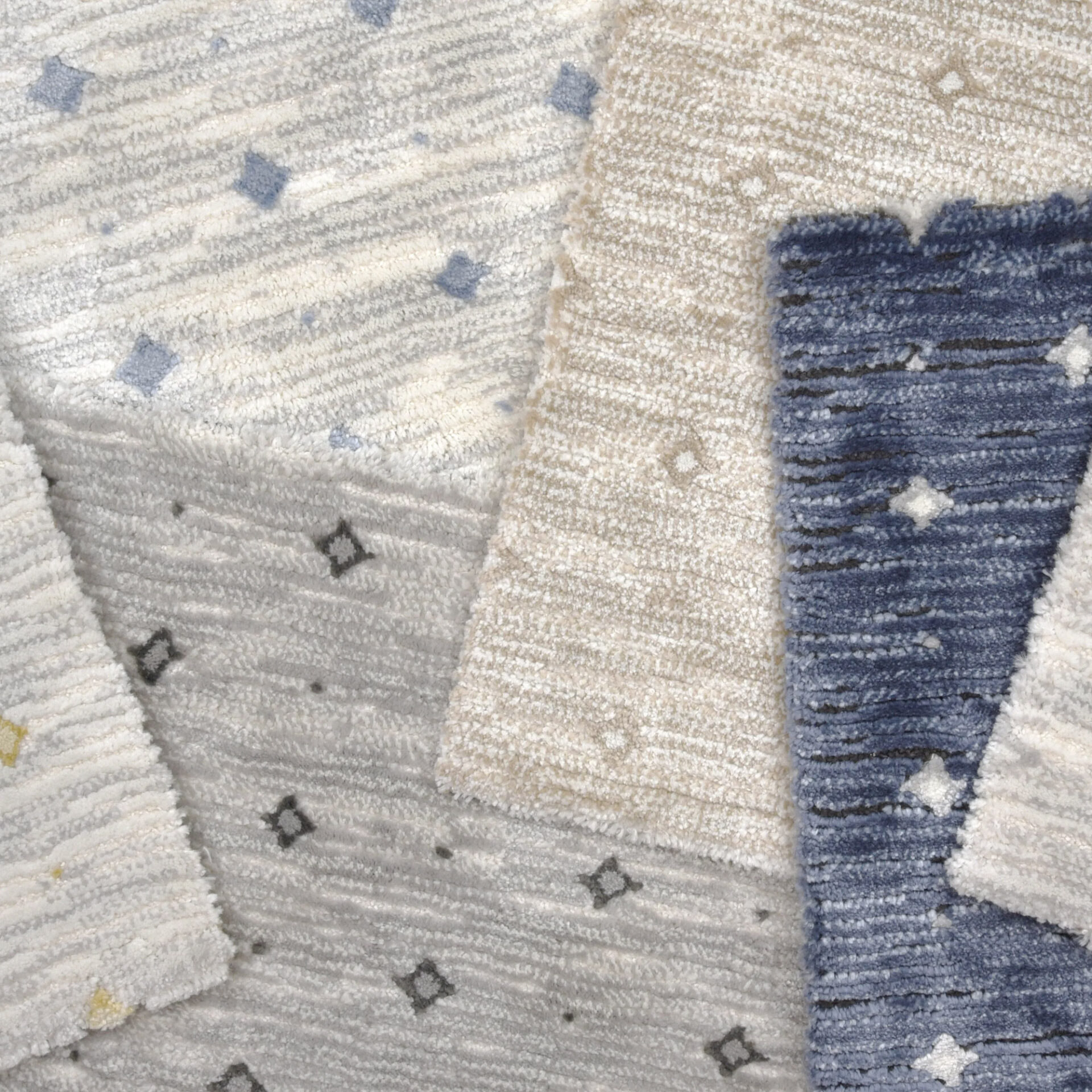 Overlapping textured rug swatches in cream, gray, beige, and blue, each with diamond and dot patterns.