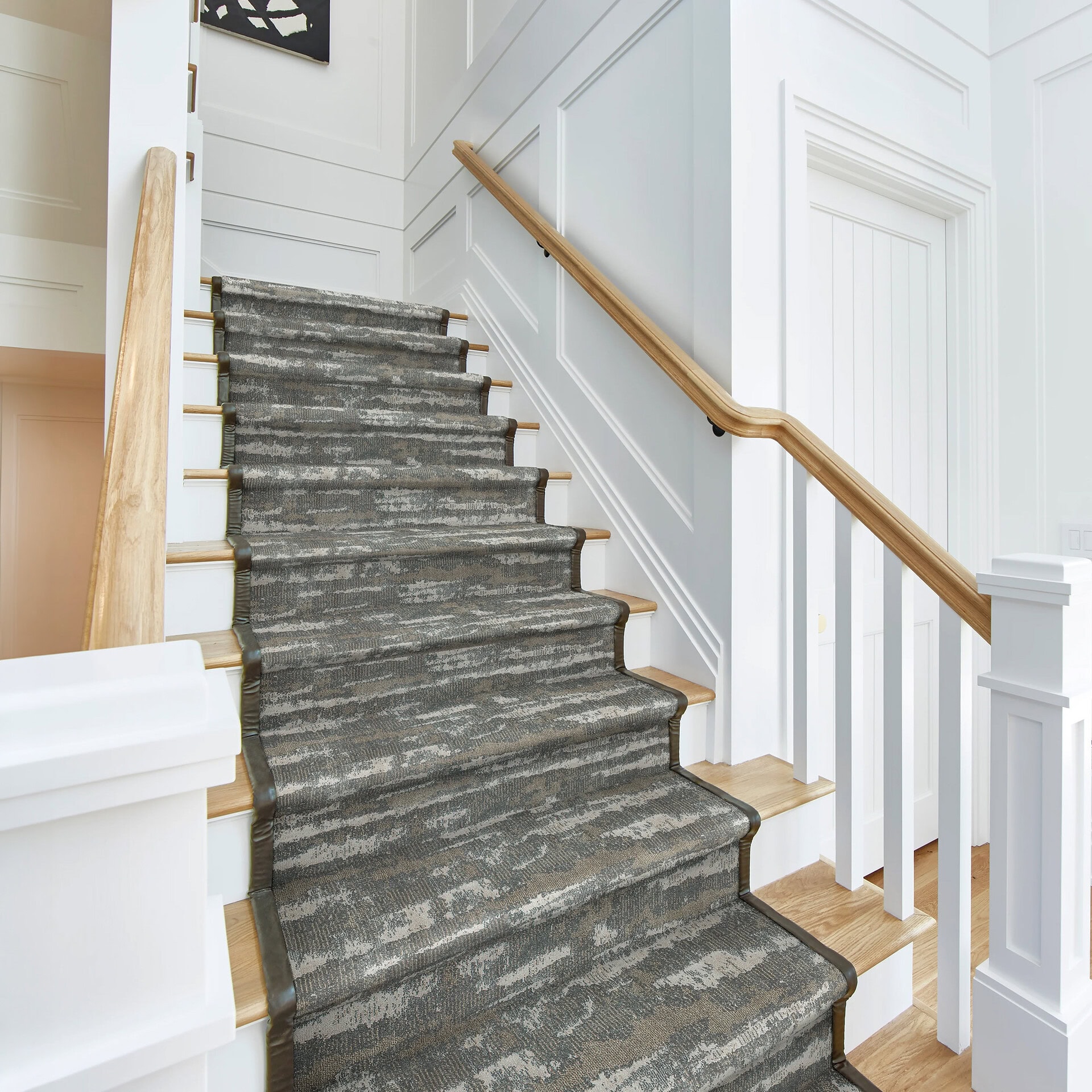 Woven carpet runner on staircase enhances elegance and comfort.