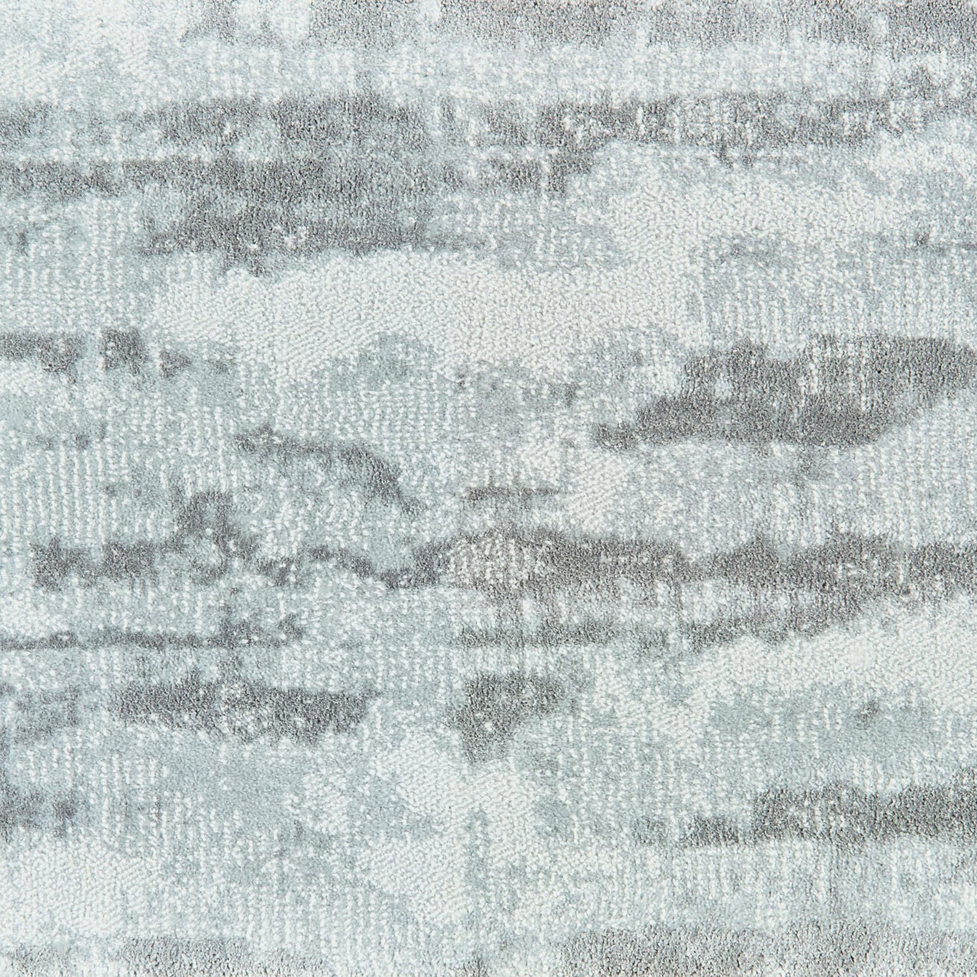 Elegant woven carpet with a textured, abstract design in soft gray tones.