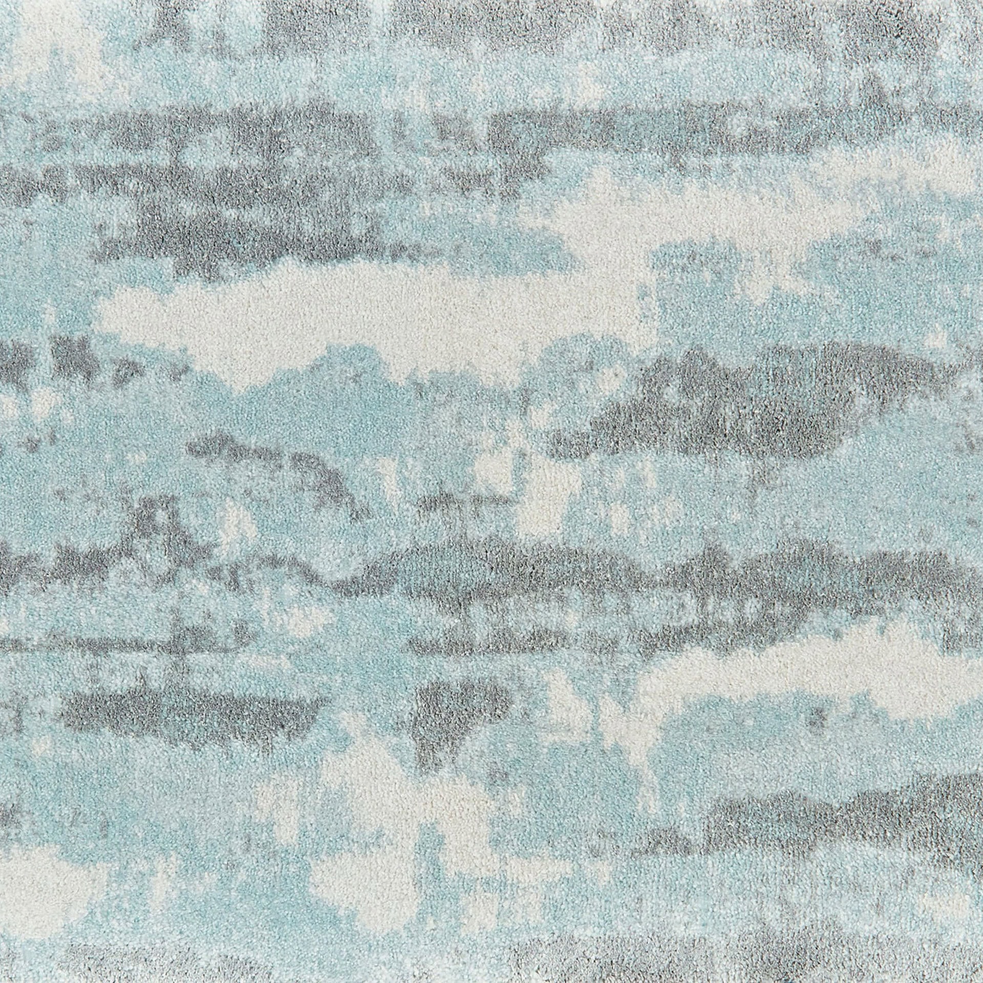 Woven carpet featuring abstract blue and gray patterns for modern interior decor.