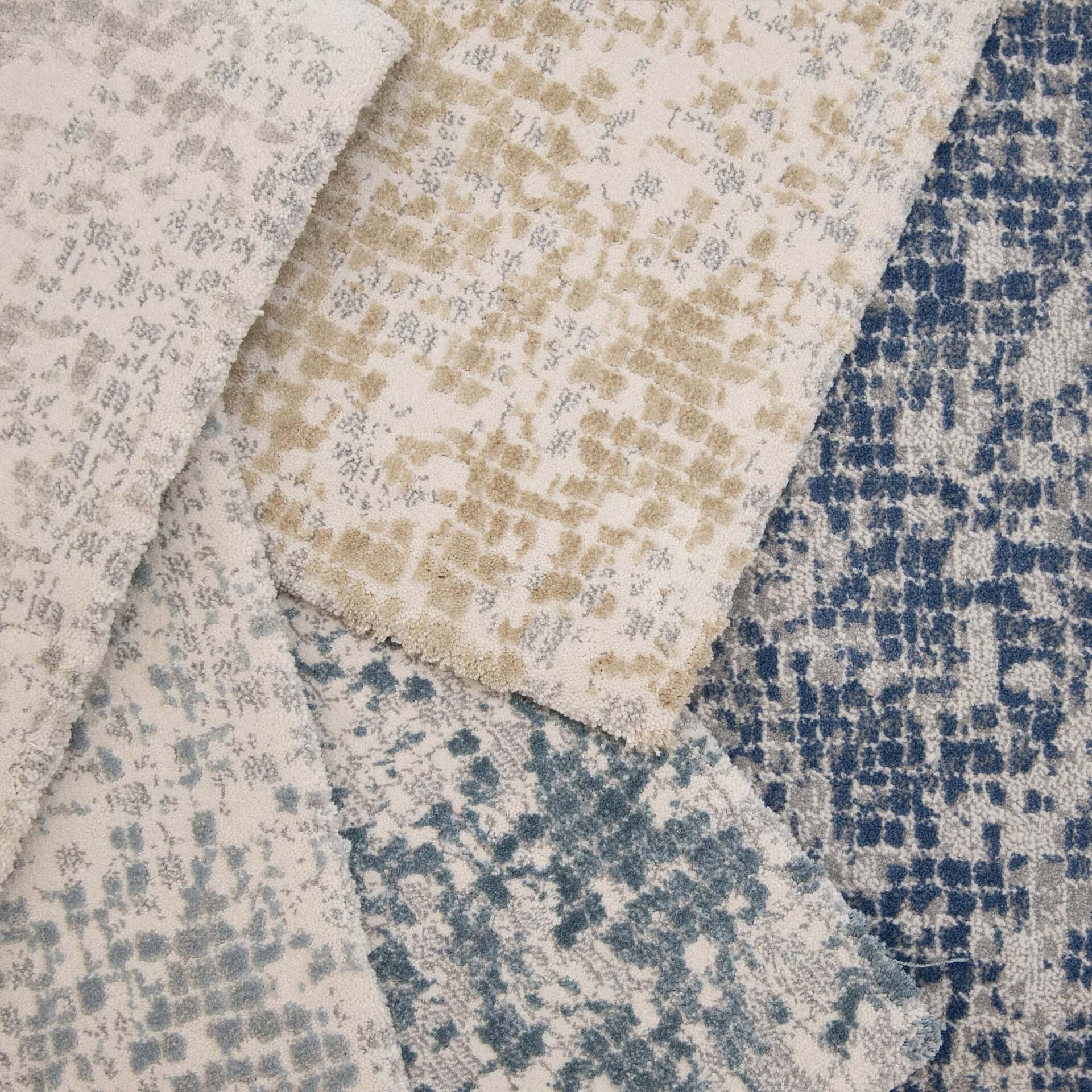 Woven area rug with a modern abstract pattern in neutral tones and blue accents.