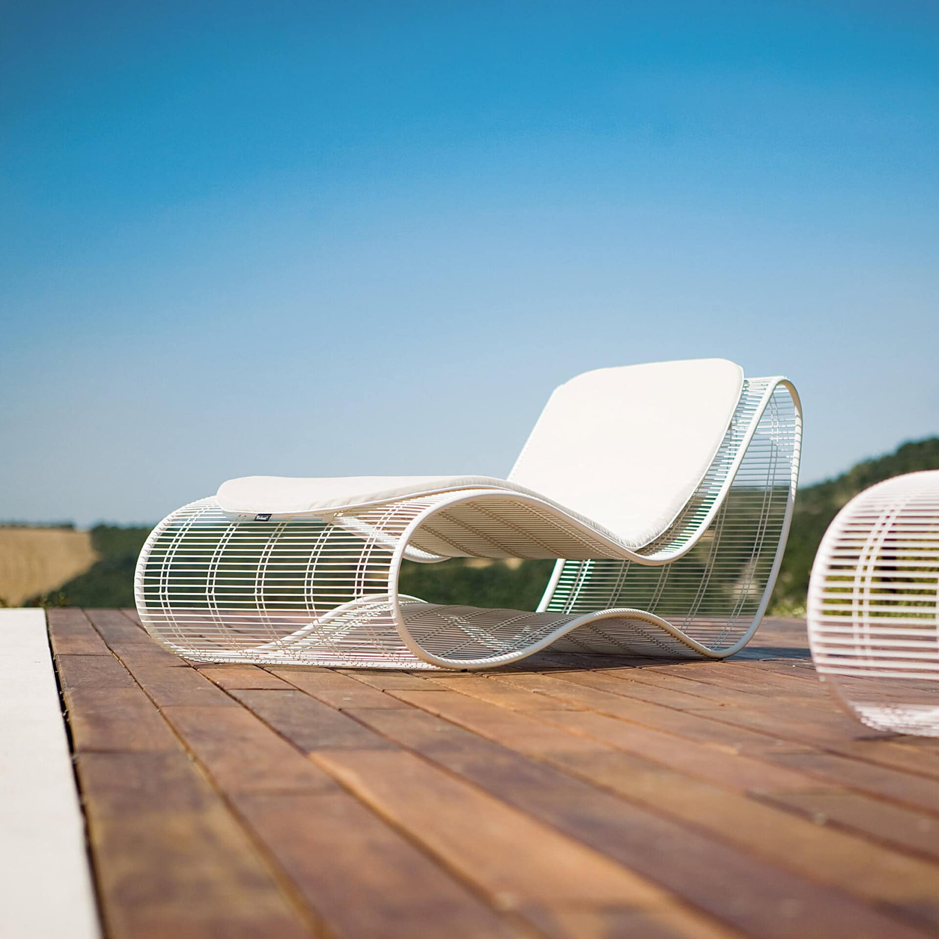 Modern Breez outdoor chaise lounge with sleek metal frame and white cushion.